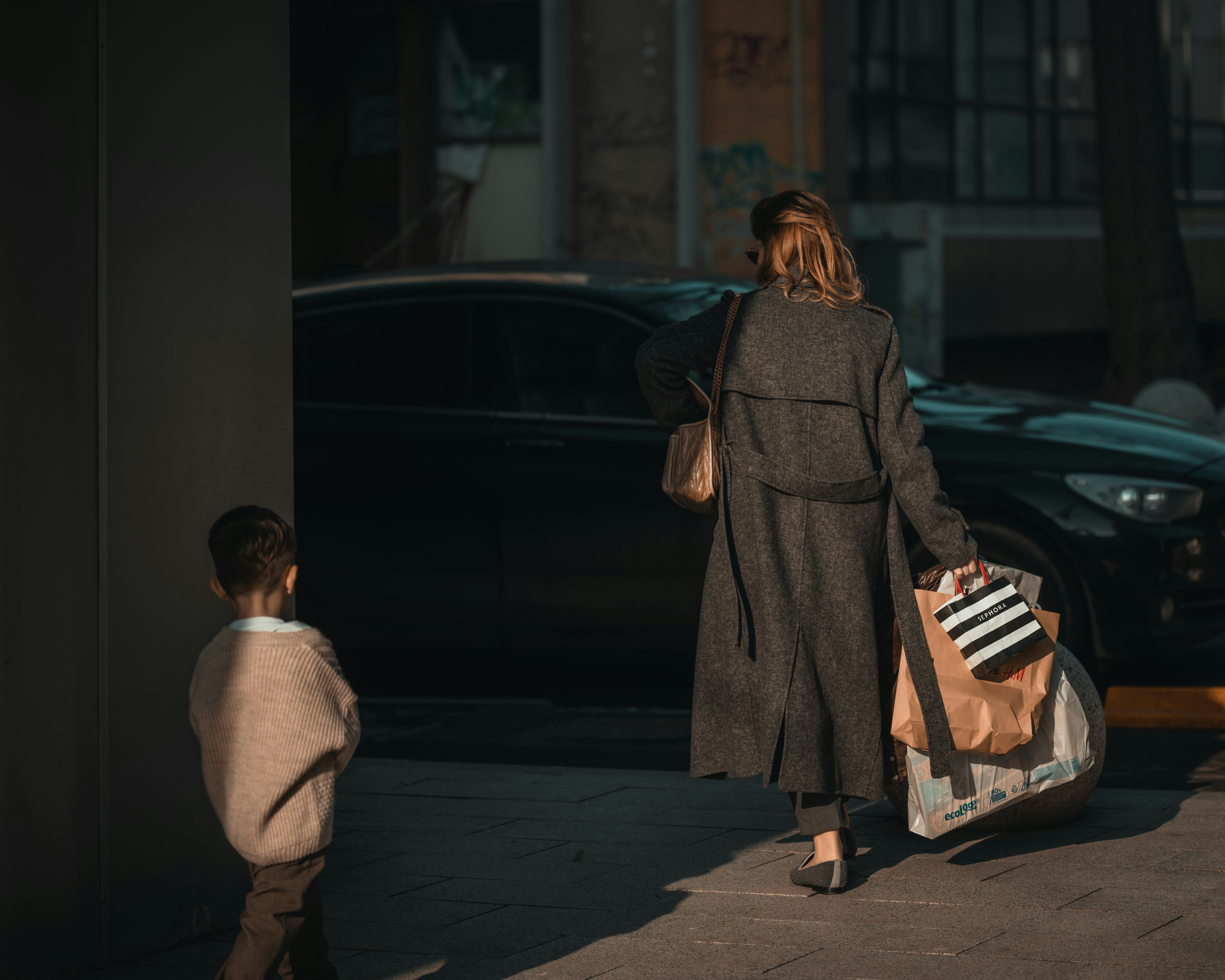Woman and child walking with shopping bags.