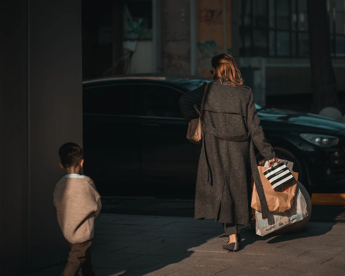 Woman and child walking with shopping bags.
