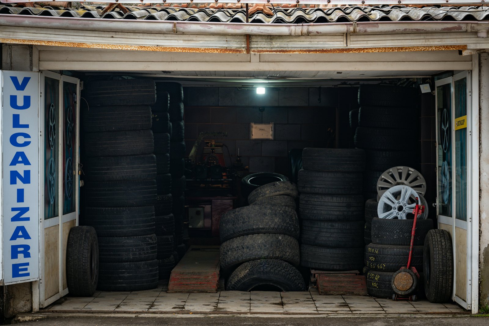 A tire shop garage with stacks of tires and rims
