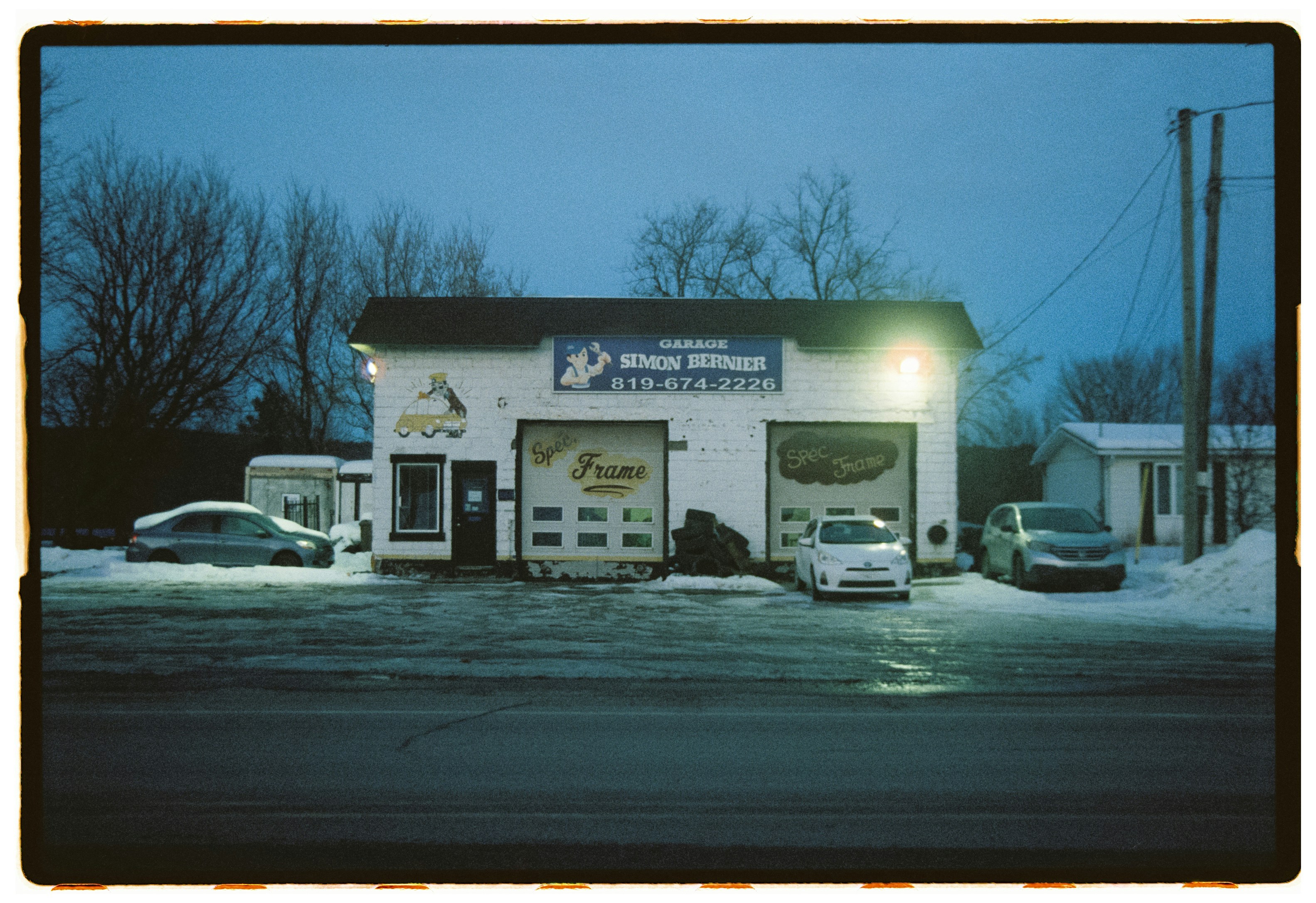 Garage with cars in snowy weather at dusk