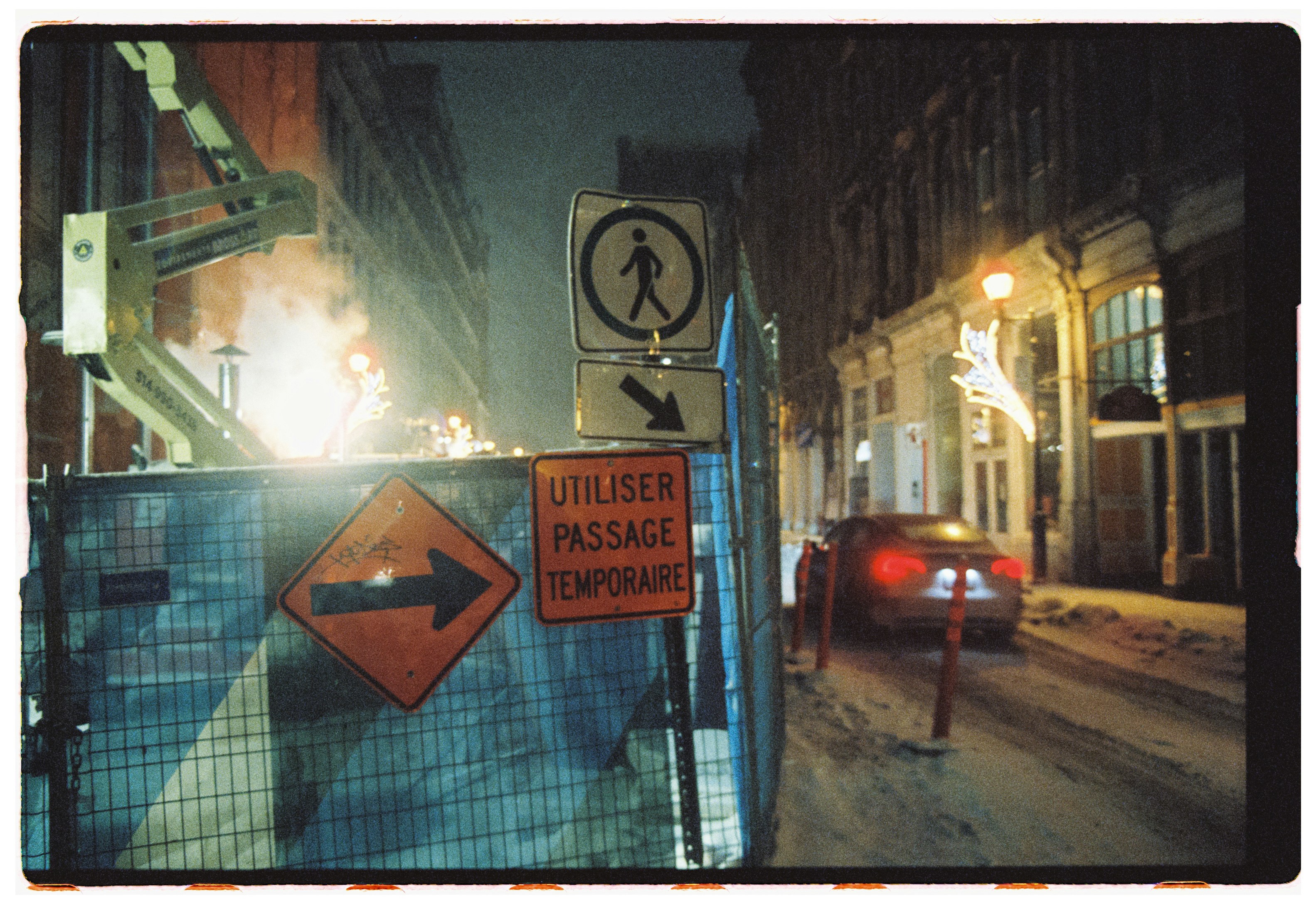 Street construction with detour signs at night