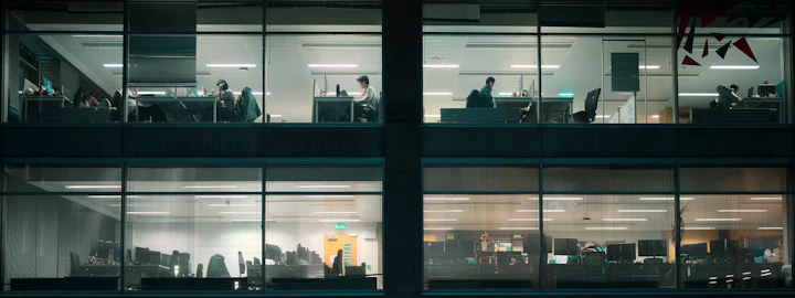 Office building windows at night with people working inside