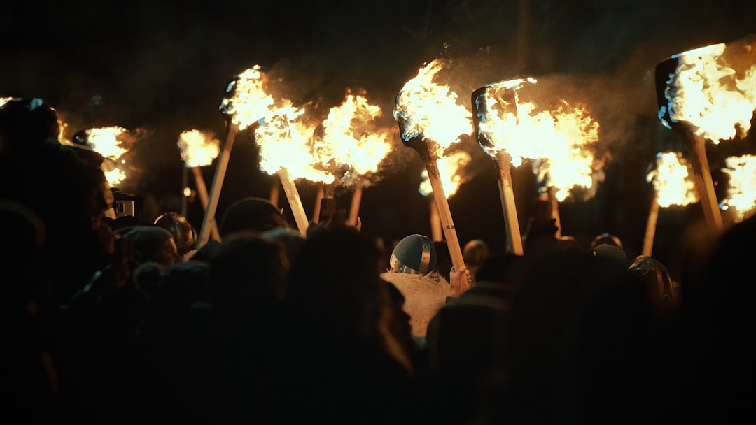 A crowd holding torches at night