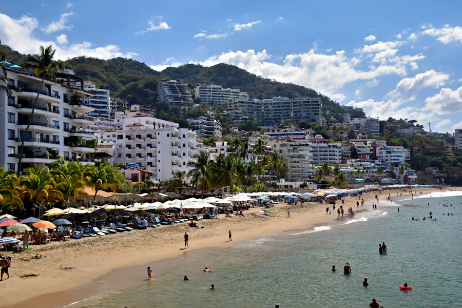 Playa con sombrillas y la ciudad en la colina, Puerto Vallarta
