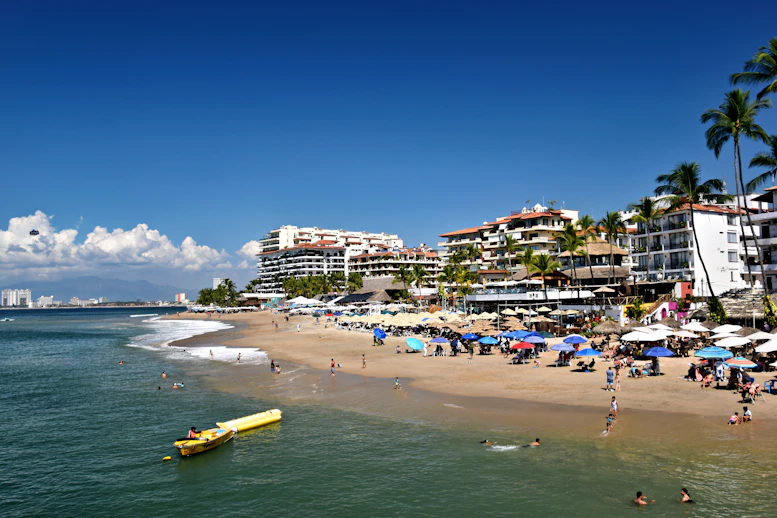 People relax on a sunny beach with ocean waves