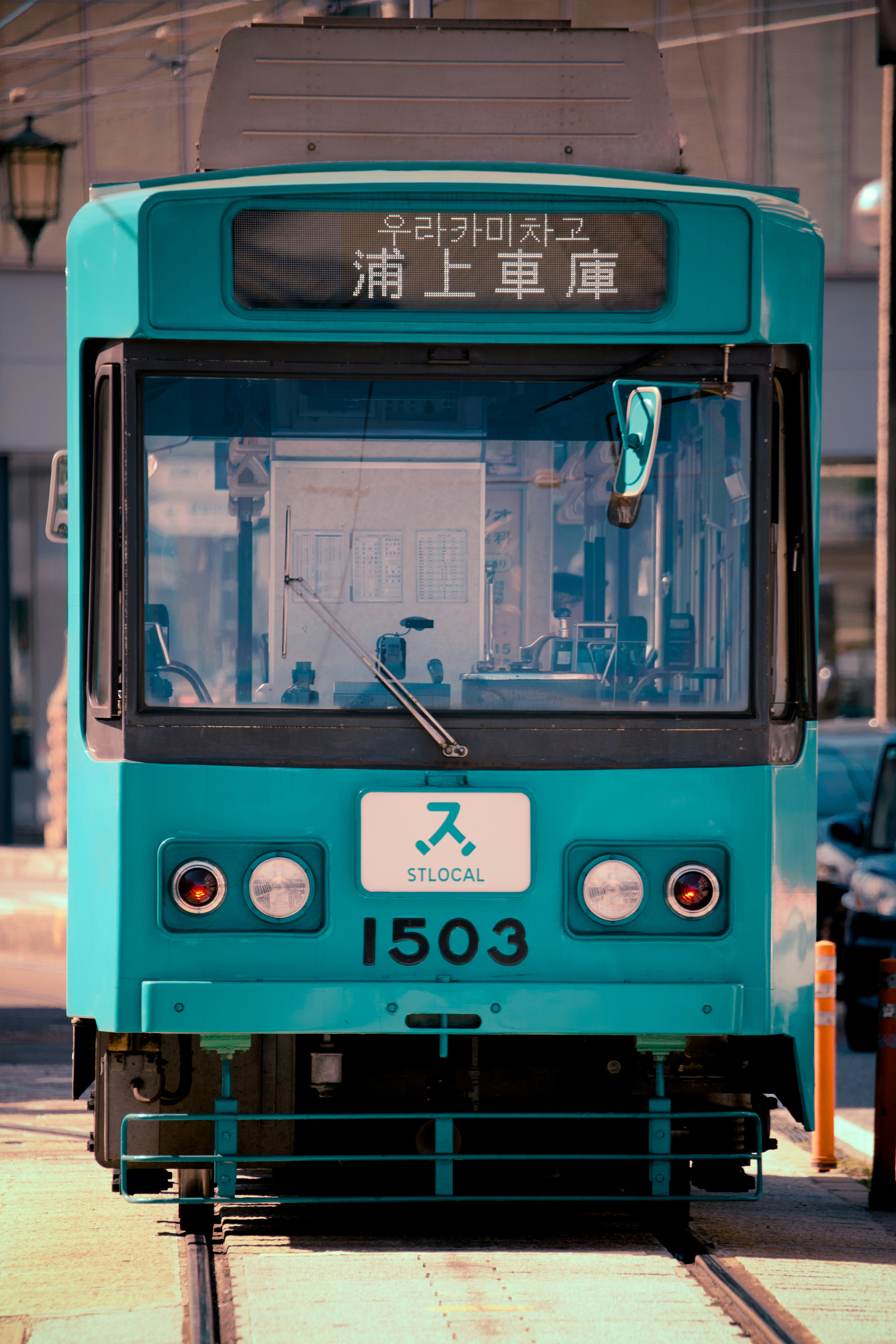 Teal tram with japanese writing on front.