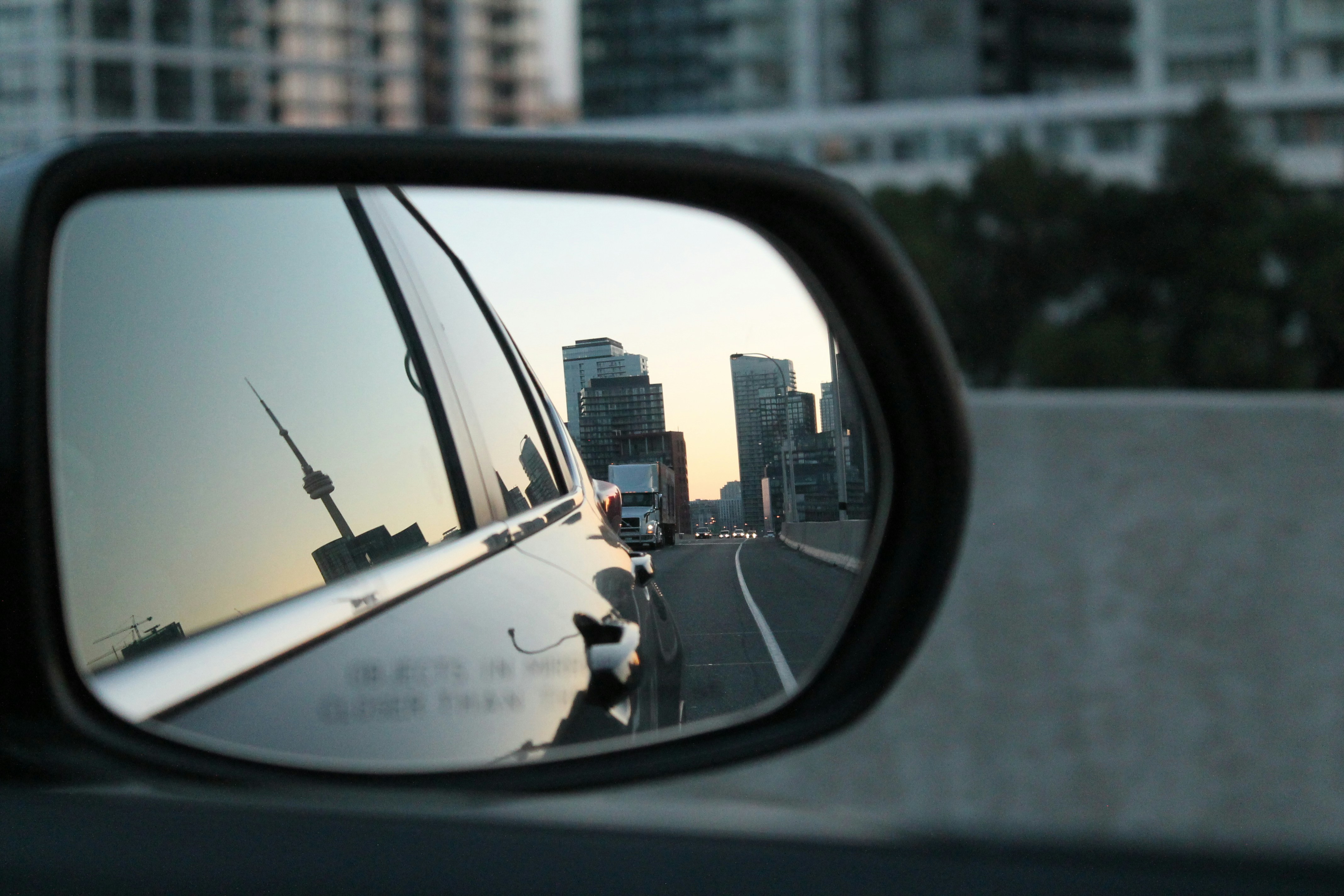 City skyline reflected in a car's side mirror