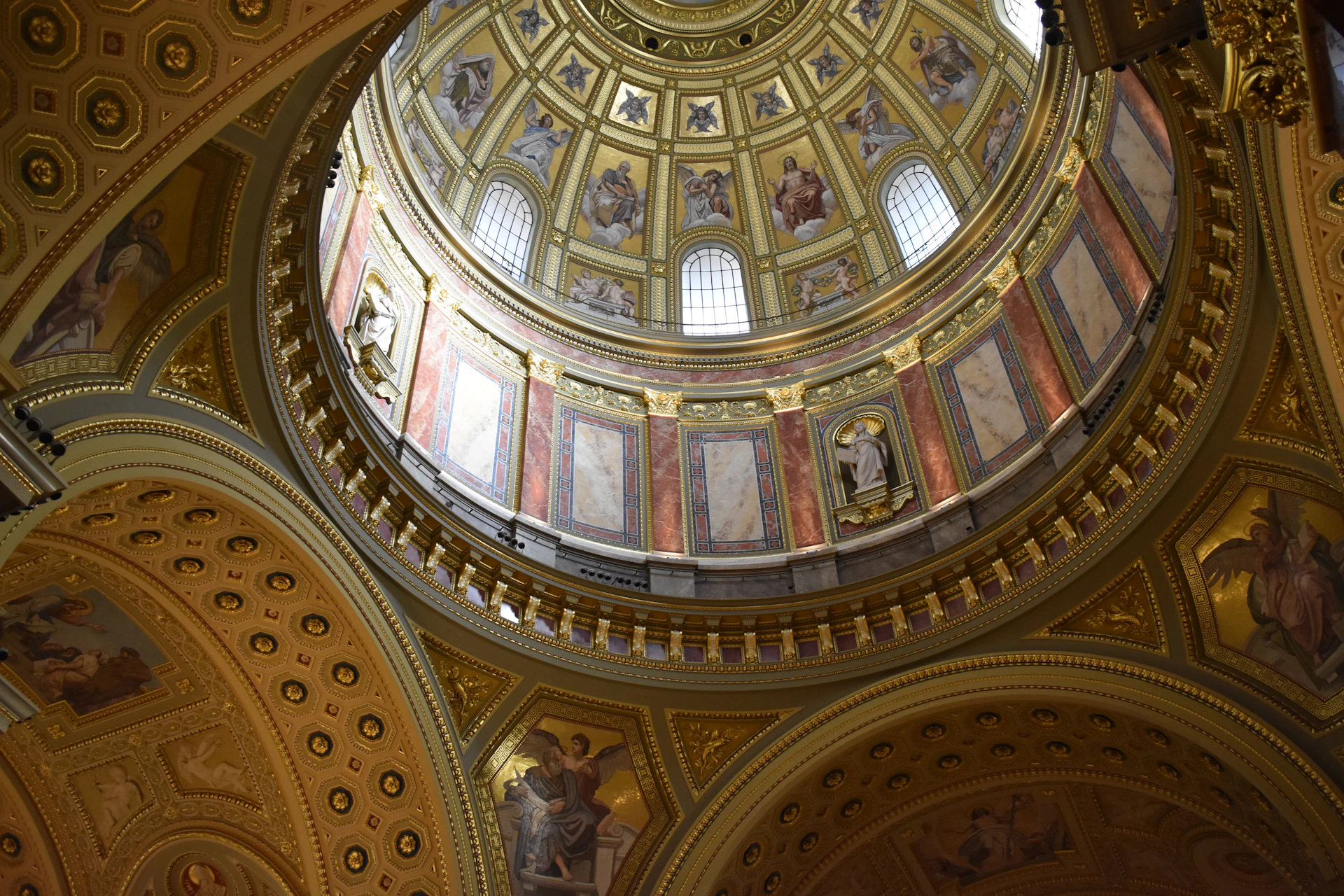 Ornate golden dome interior with painted murals and windows