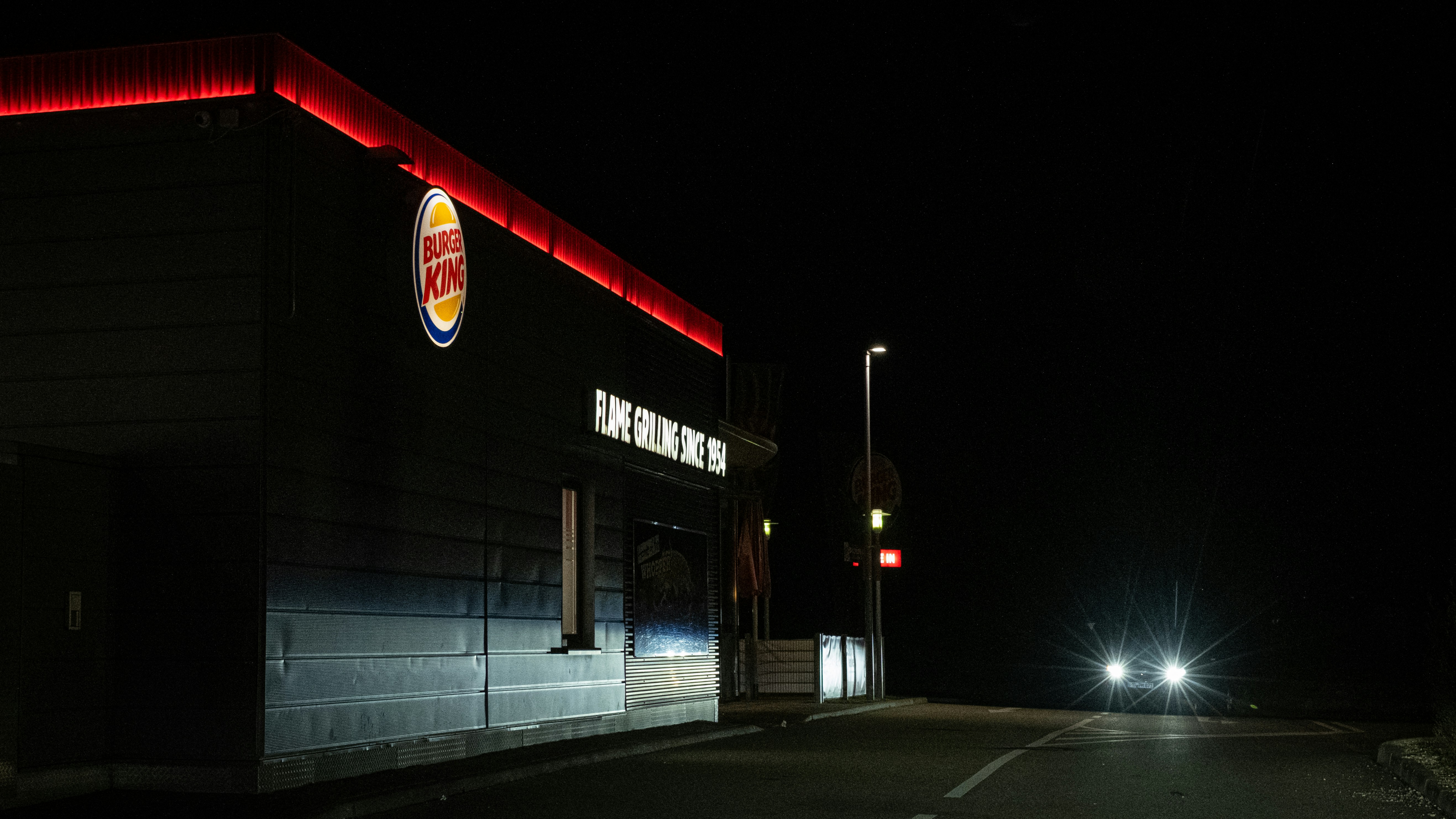 Burger king restaurant at night with car headlights