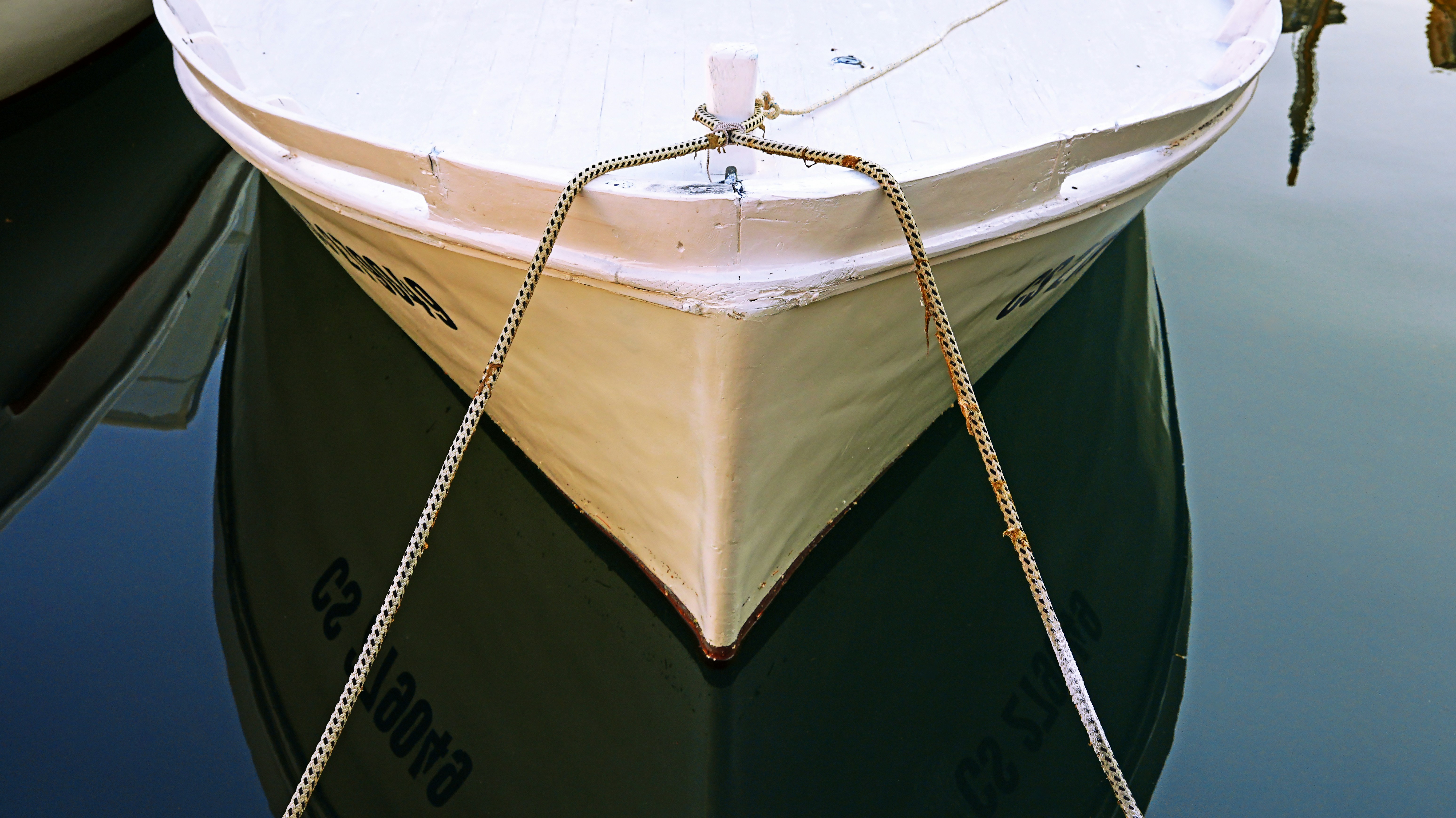 Ein weißes Boot treibt auf dunklem Wasser