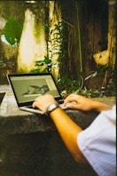 Person using a laptop with architectural design on screen.