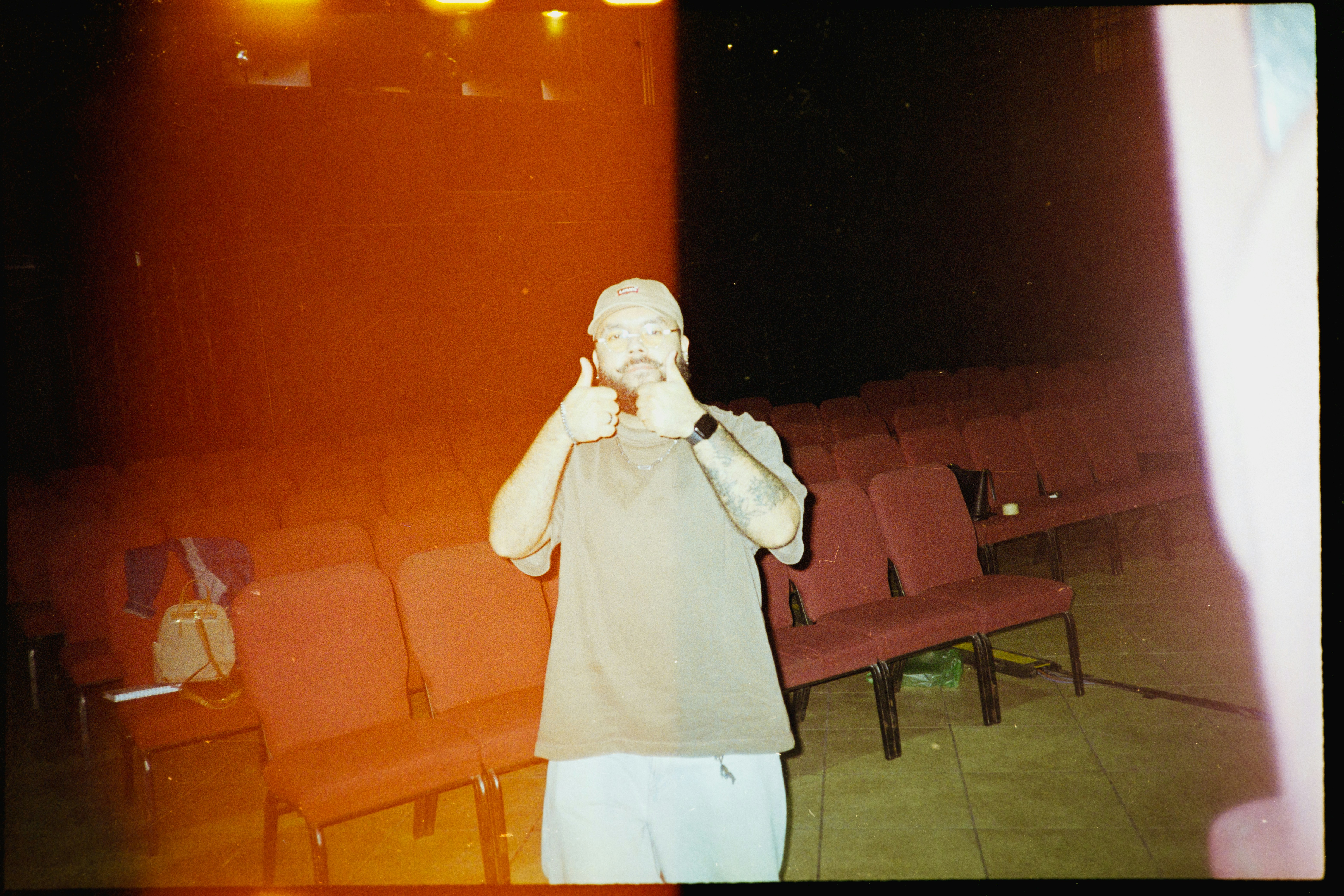 Man giving thumbs up in empty auditorium seats