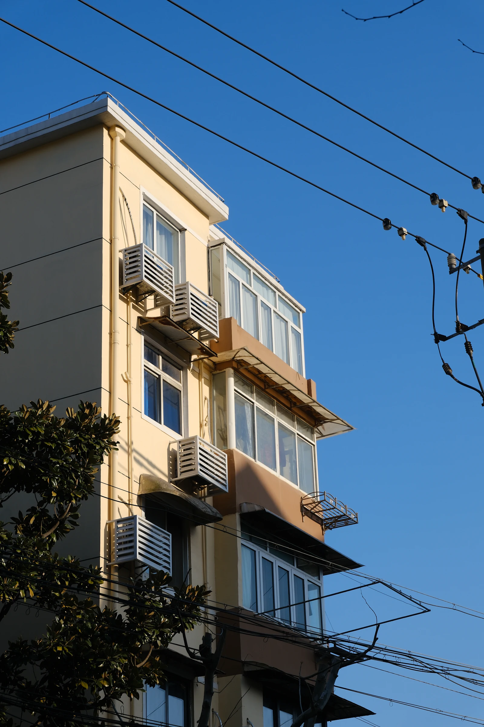 Tall building facade with rows of windows and air conditioning units