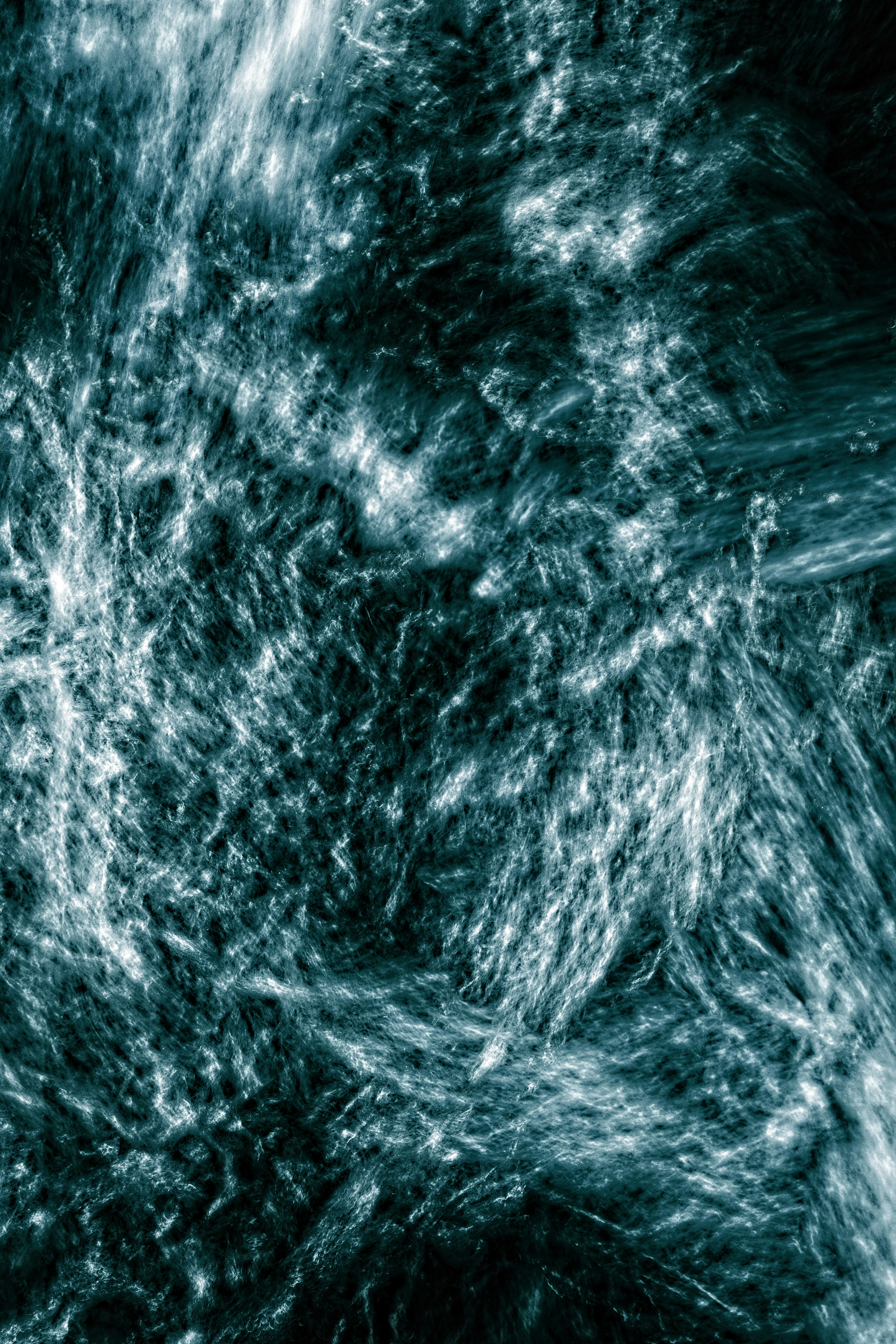 Abstract swirling teal and white patterns