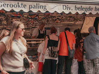 People at a market stall selling smoked fish