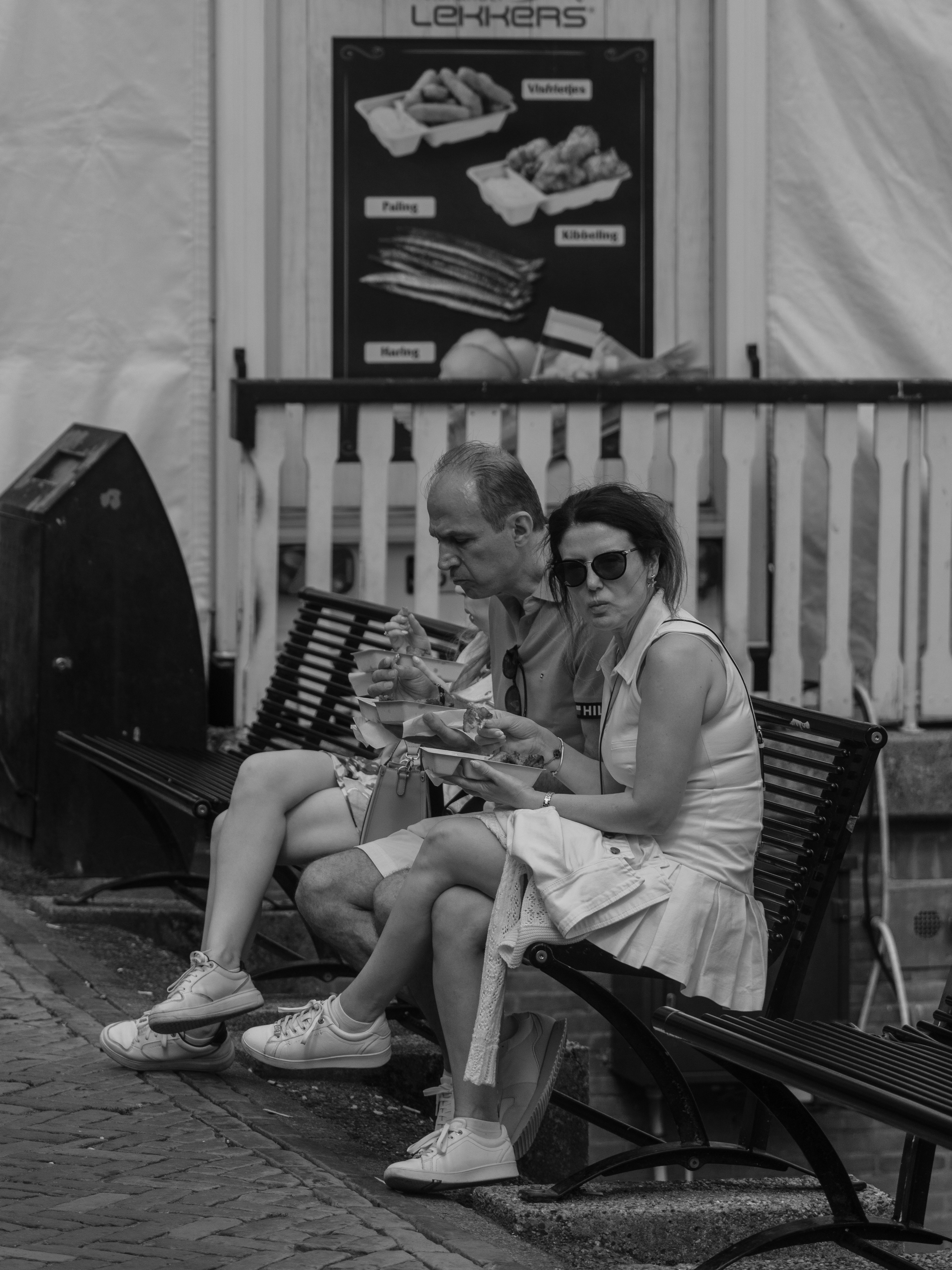 Couple sitting on a bench reading menus