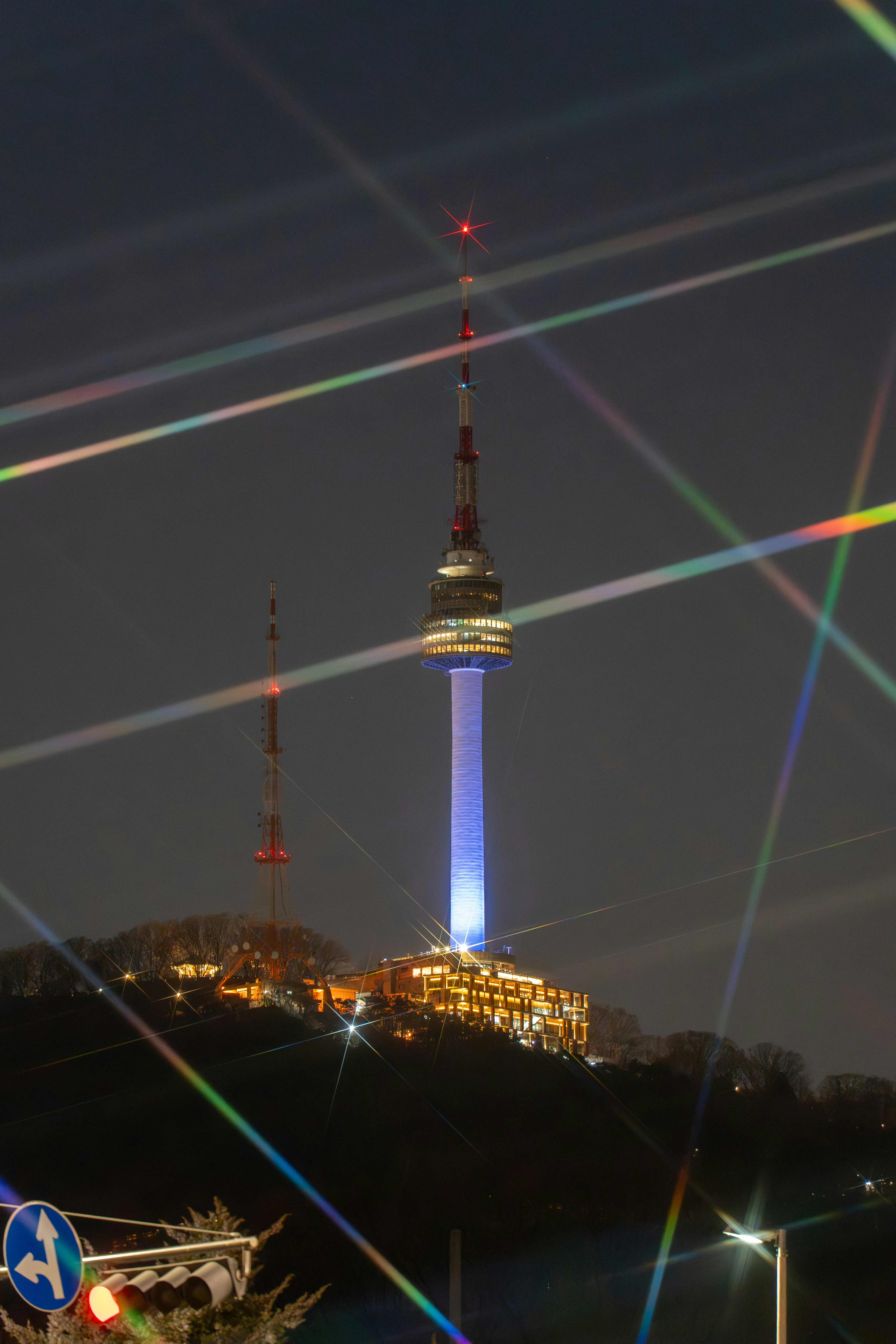 Nighttime view of a tall tower with colorful light streaks