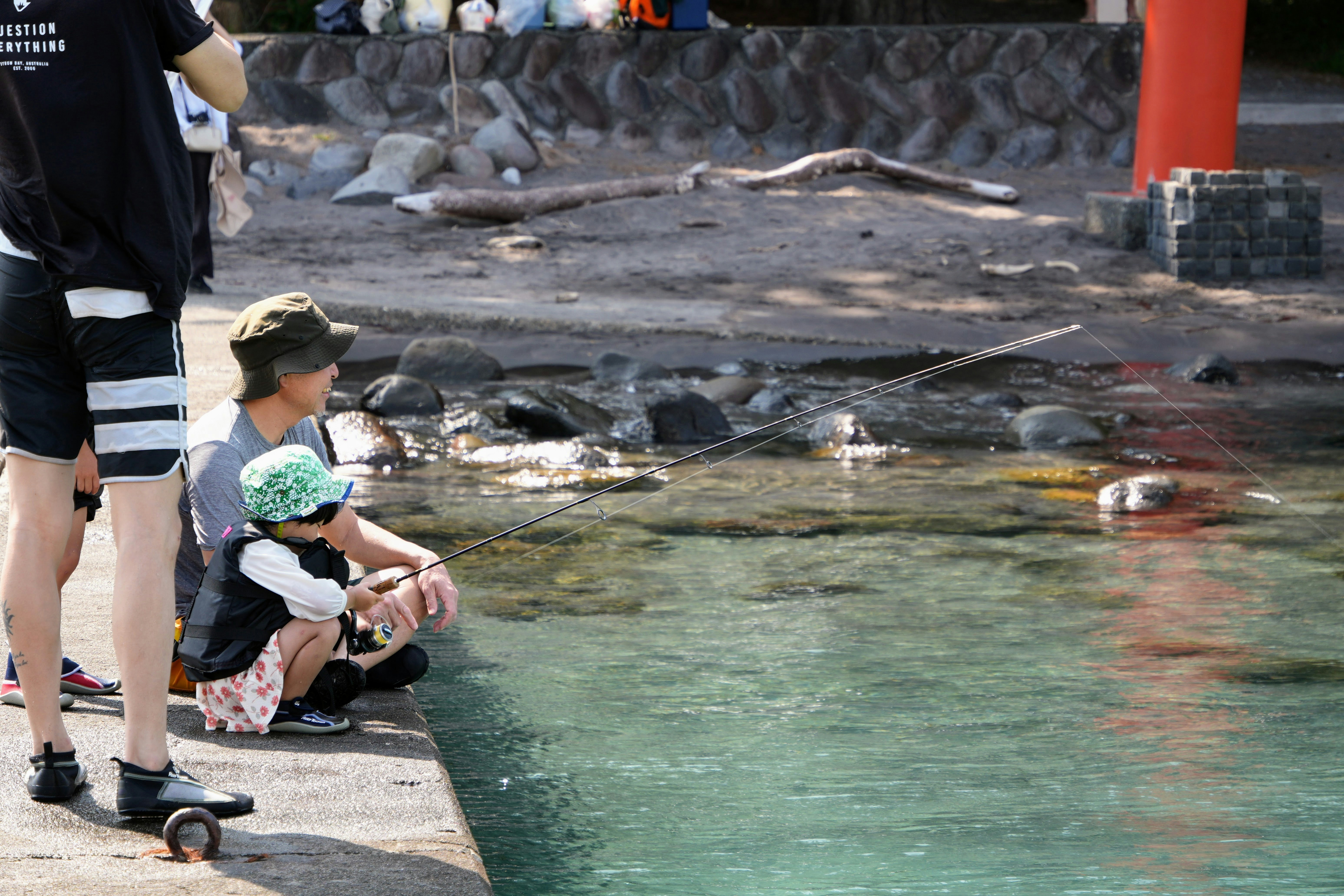 Adult and child by clear water