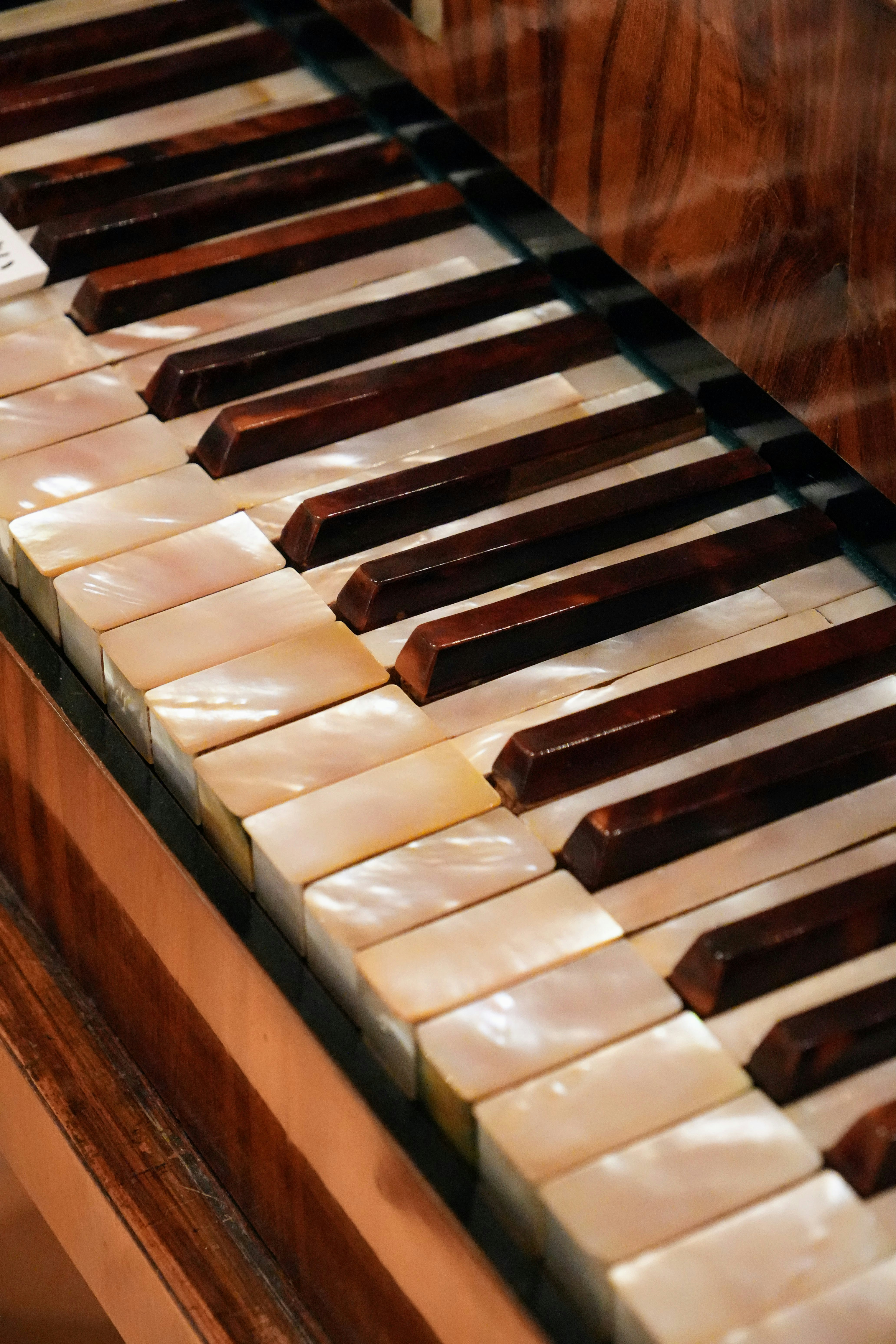 Close-up of antique piano keys with mother-of-pearl inlay.