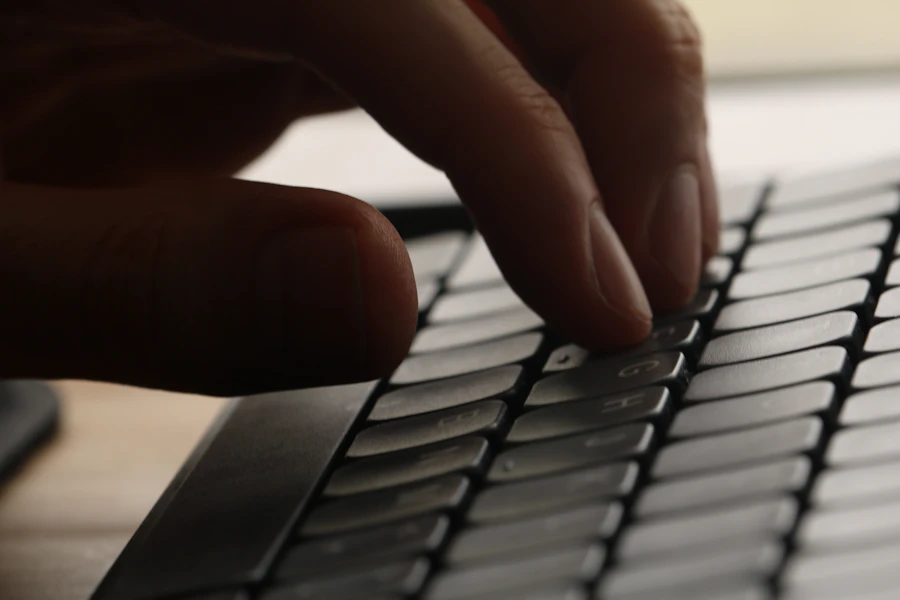 Close-up of a hand typing on a keyboard, reviewing a payroll run before it processes