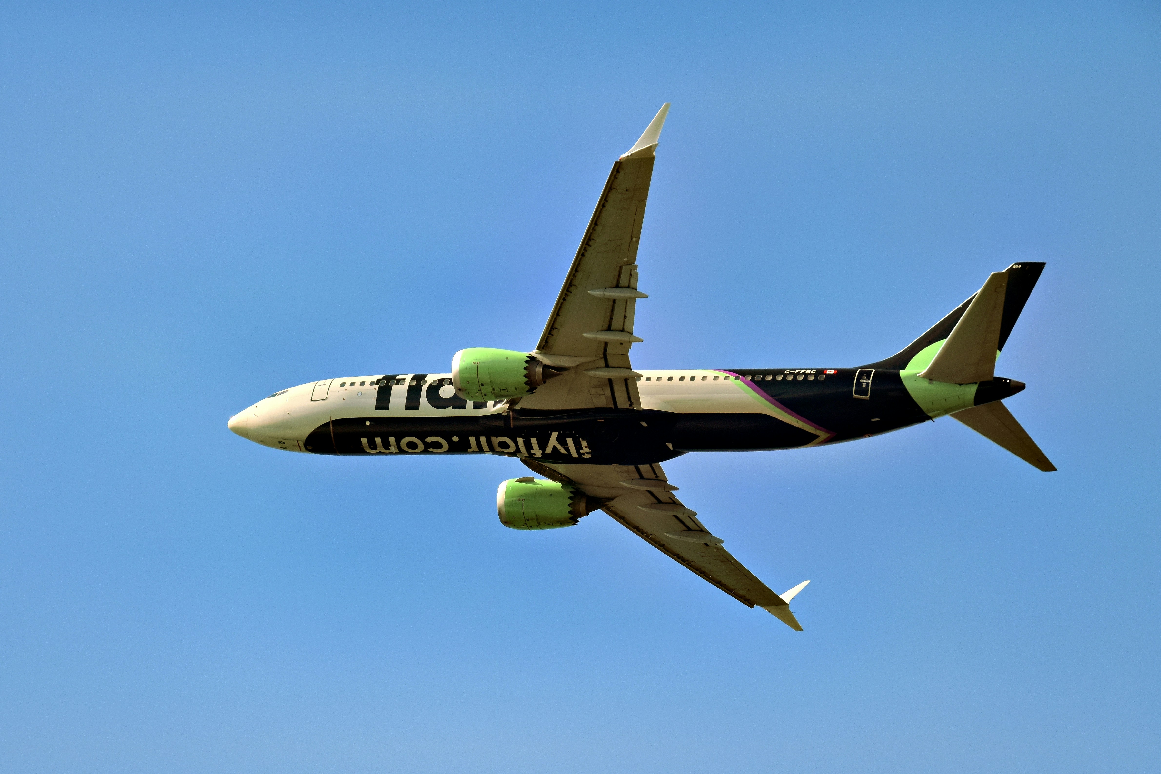 A fia.com airplane flying in the blue sky.