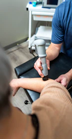 Therapist using ultrasound device on patient's arm