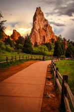A scenic path leads to a towering sandstone rock formation.