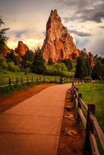 A scenic path leads to a towering sandstone rock formation.