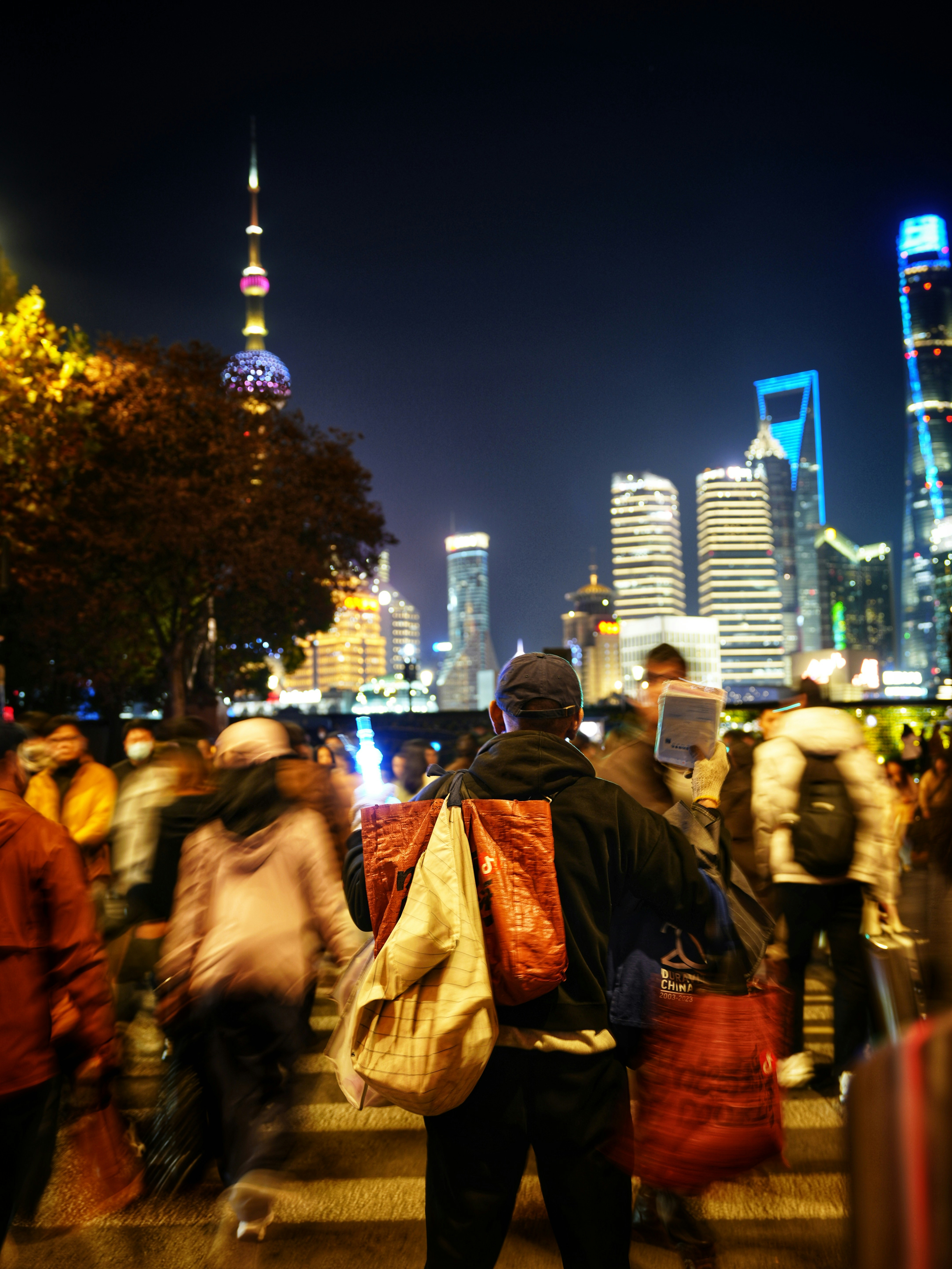 People walking on a busy city street at night.