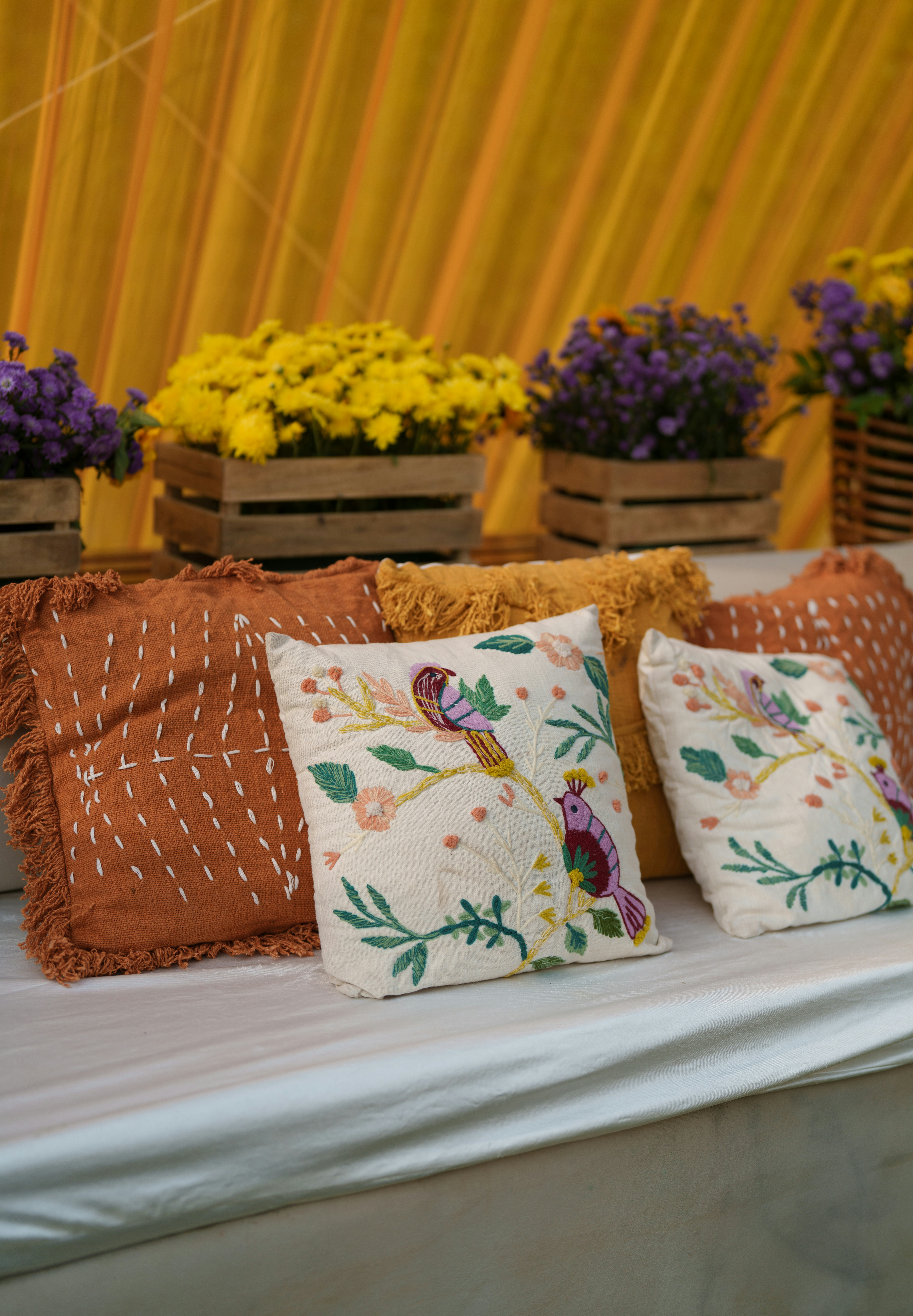 Dekorierte Kissen mit Vögeln und Blumen auf einem Sofa.