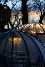 Cozy outdoor dining igloos lit with fairy lights at dusk