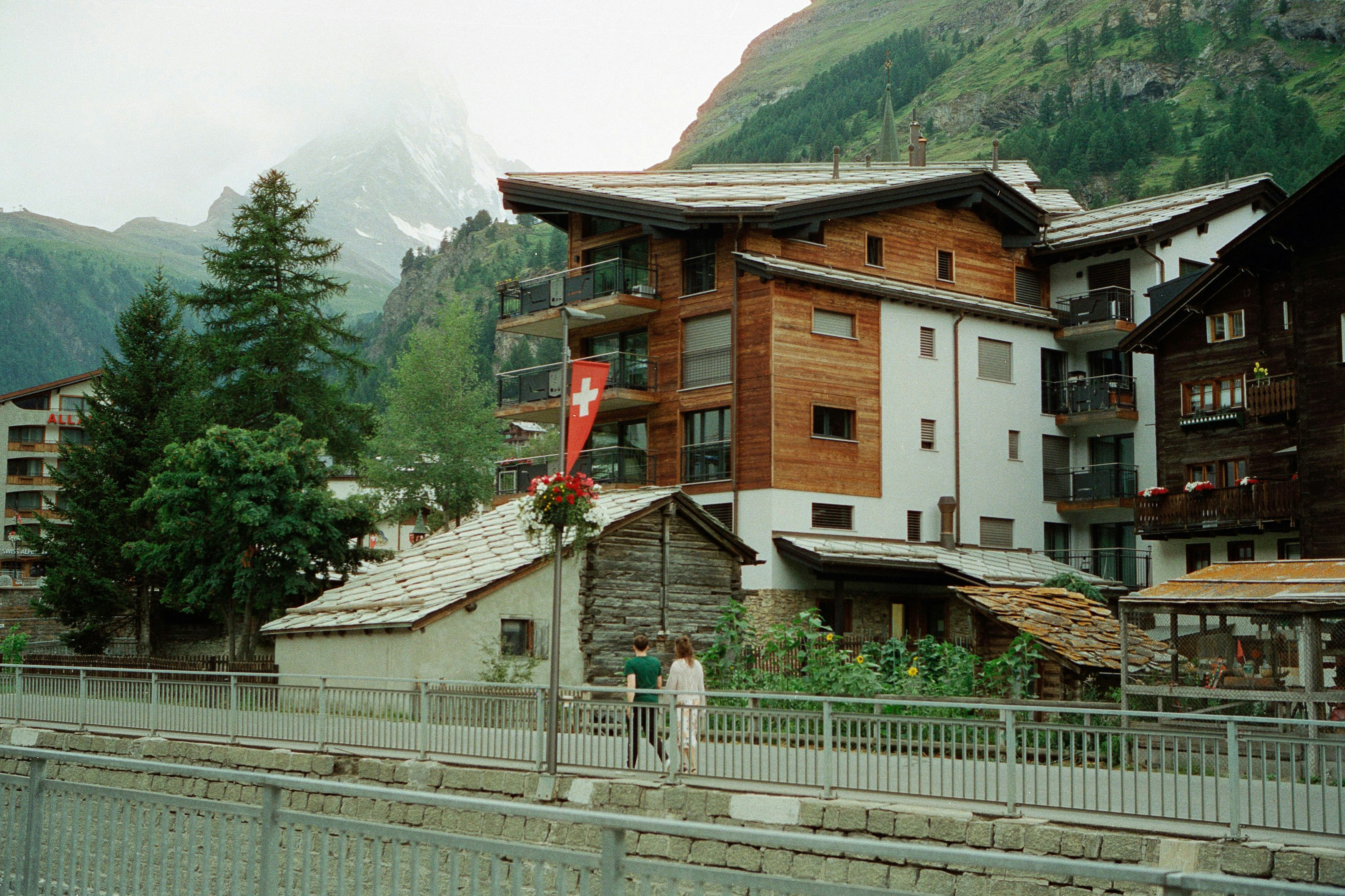 Alpine village with wooden buildings and mountains