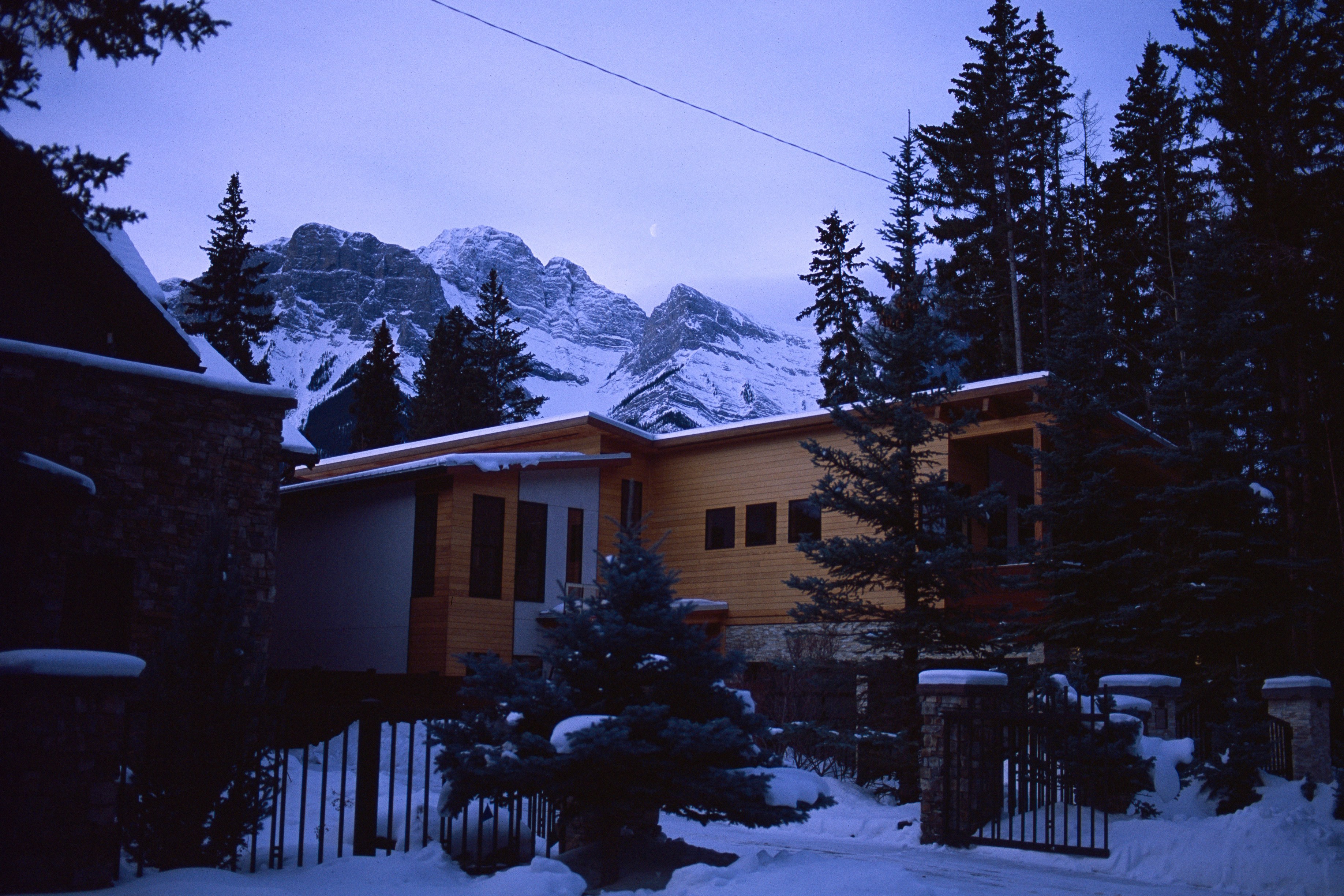 A modern house in a snowy mountain landscape.