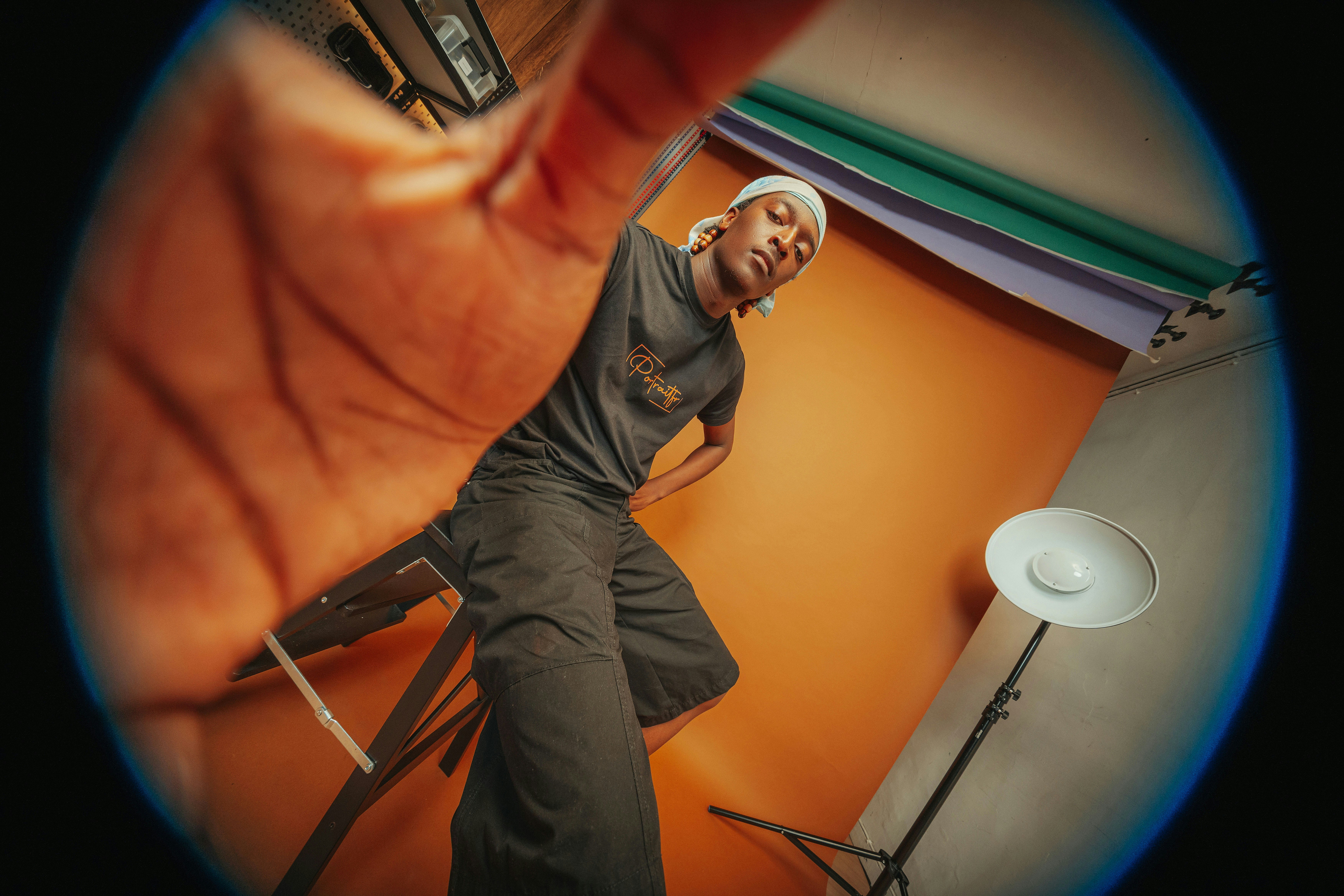 Mann mit Bandana und T-Shirt posiert im Studio