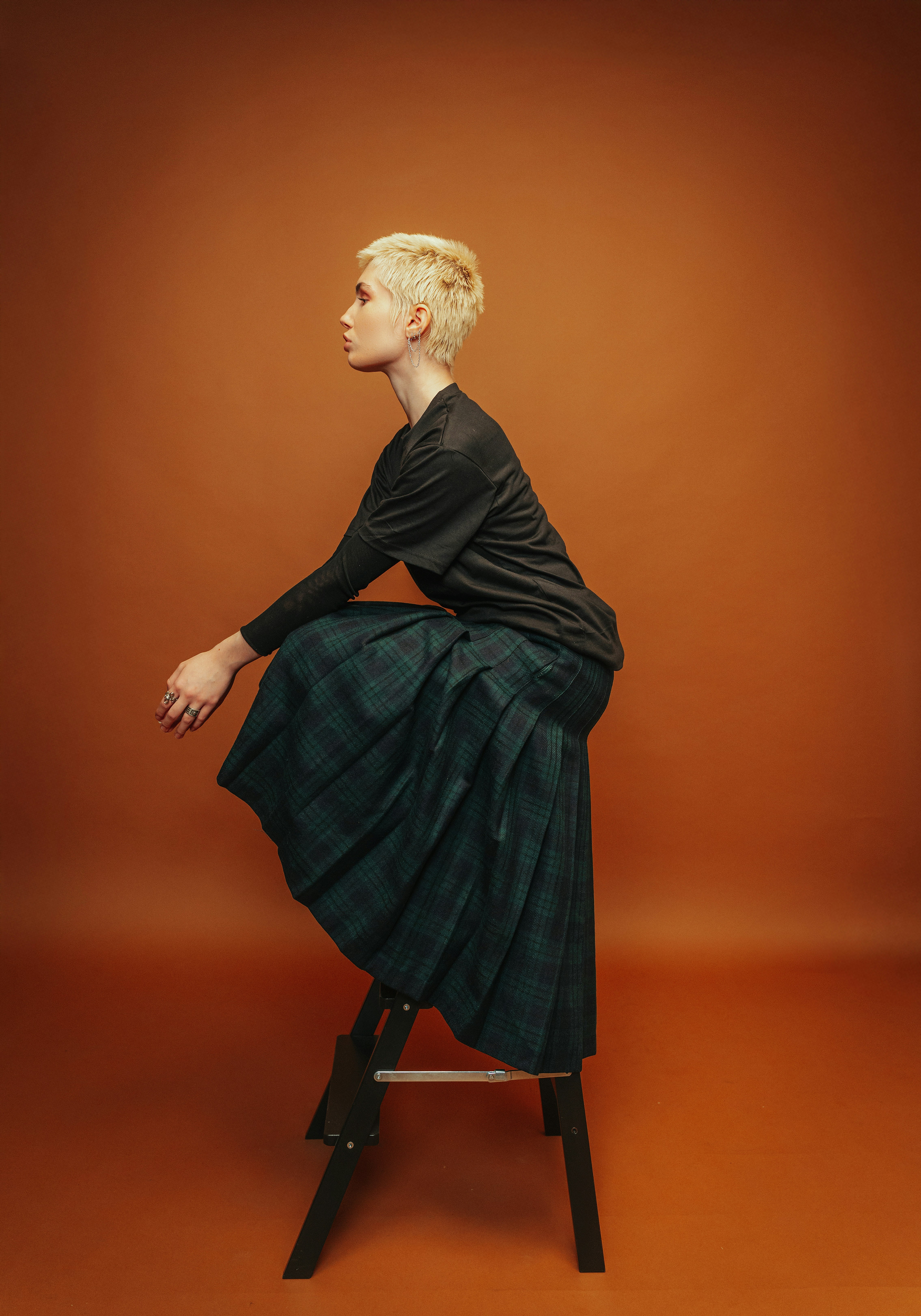 Frau mit kurzen blonden Haaren in einem karierten Rock