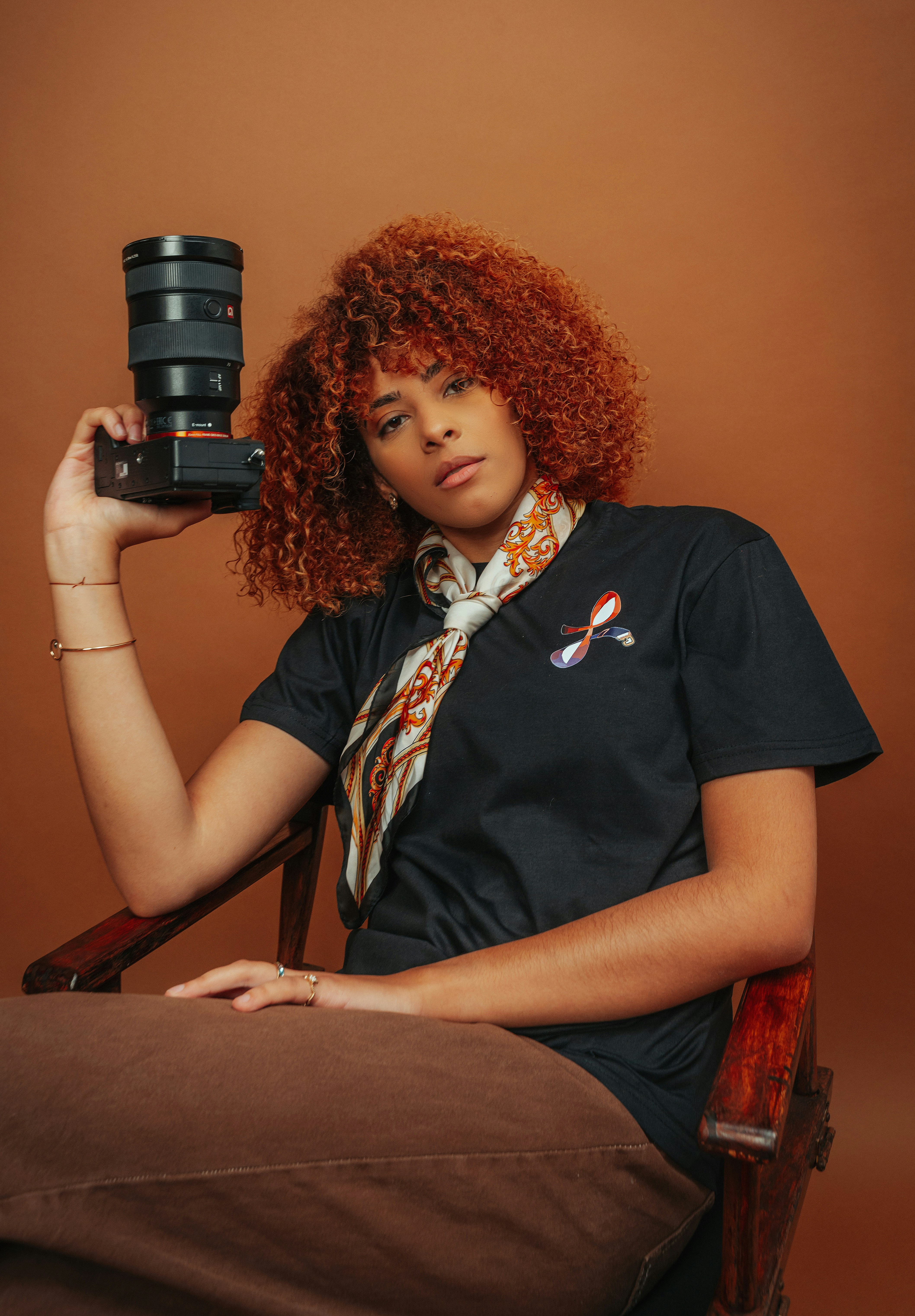 Frau mit lockigen Haaren, die eine Kamera hält