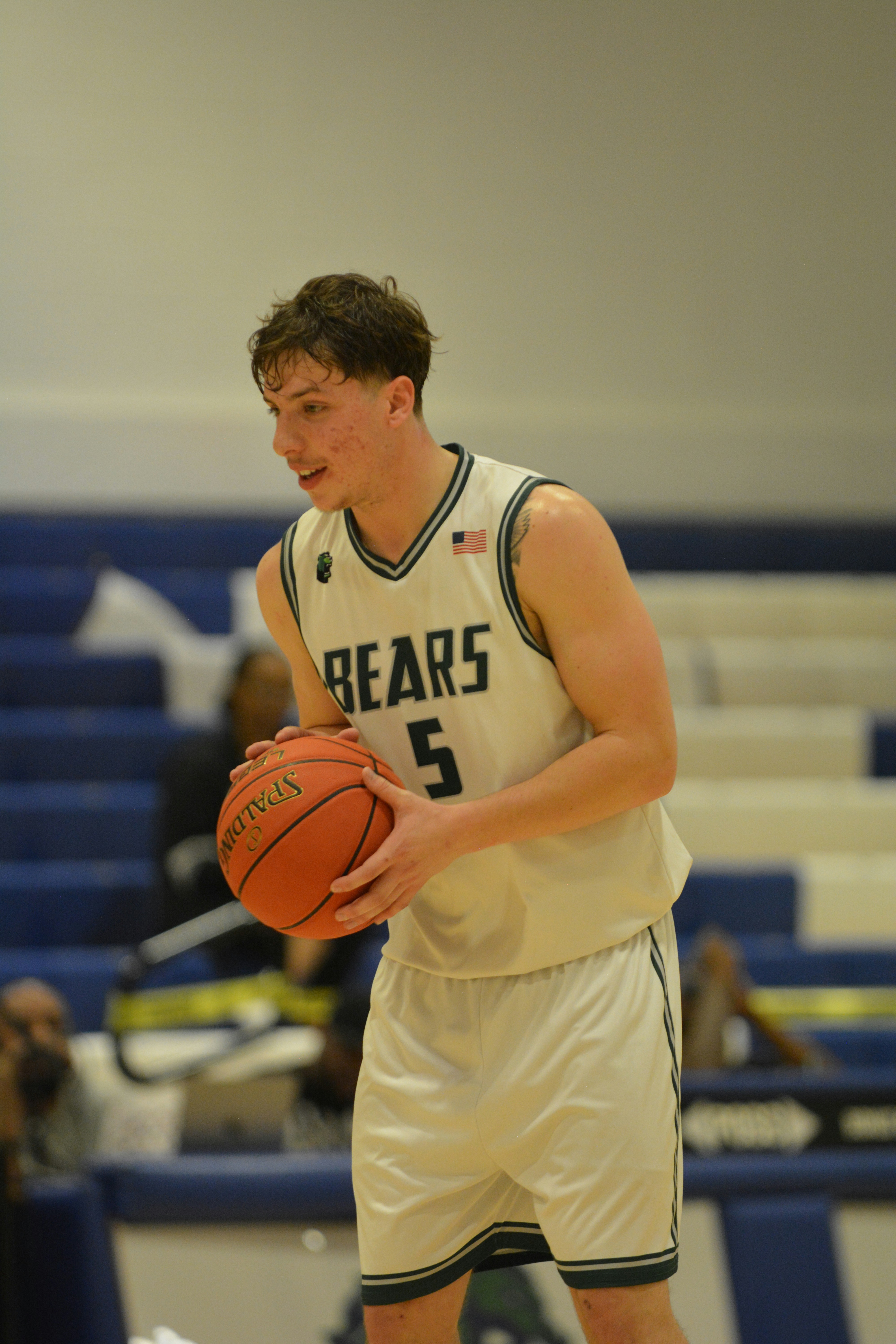Jugador de baloncesto con uniforme sosteniendo un balón