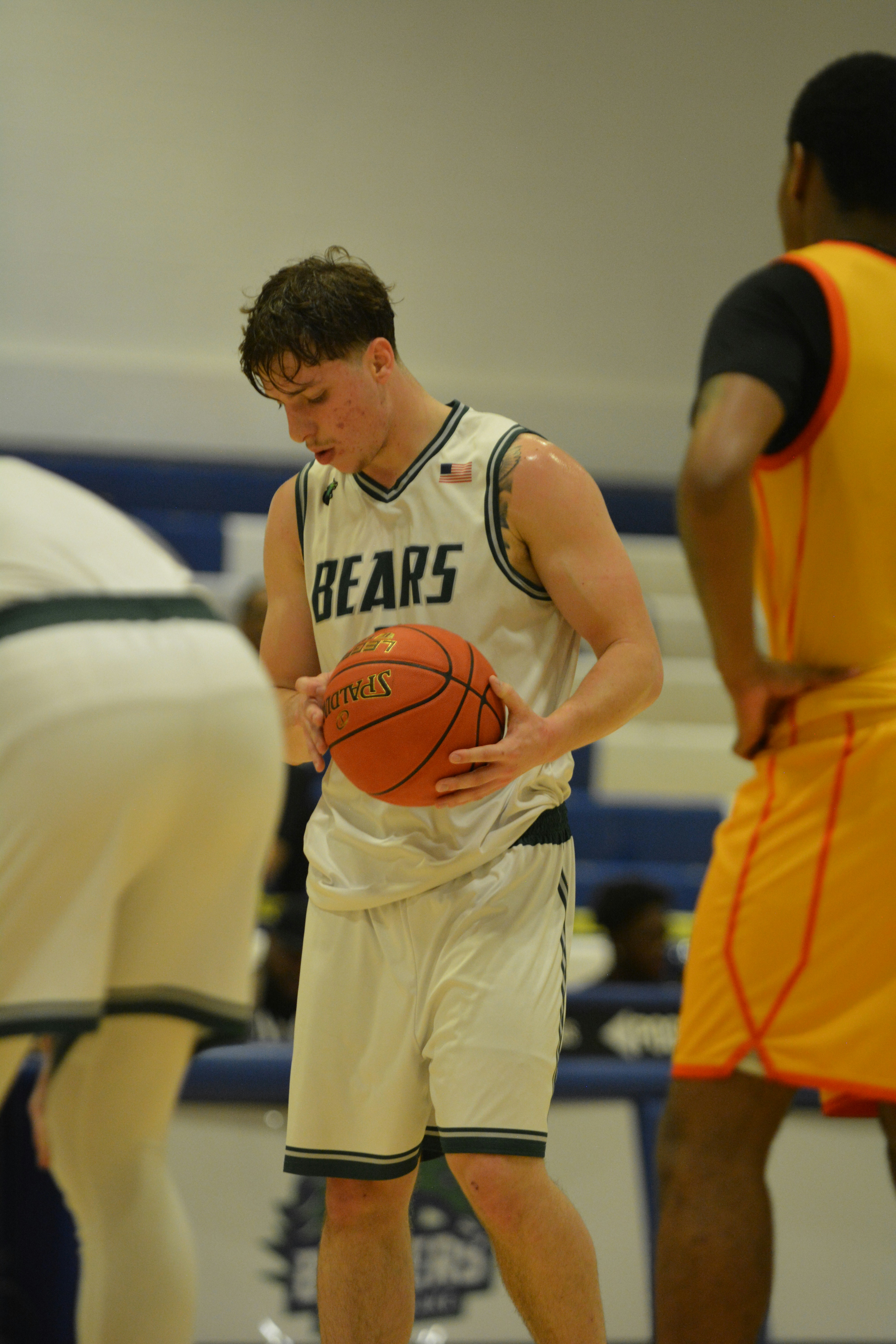 Un jugador de baloncesto sostiene un balón en la cancha.