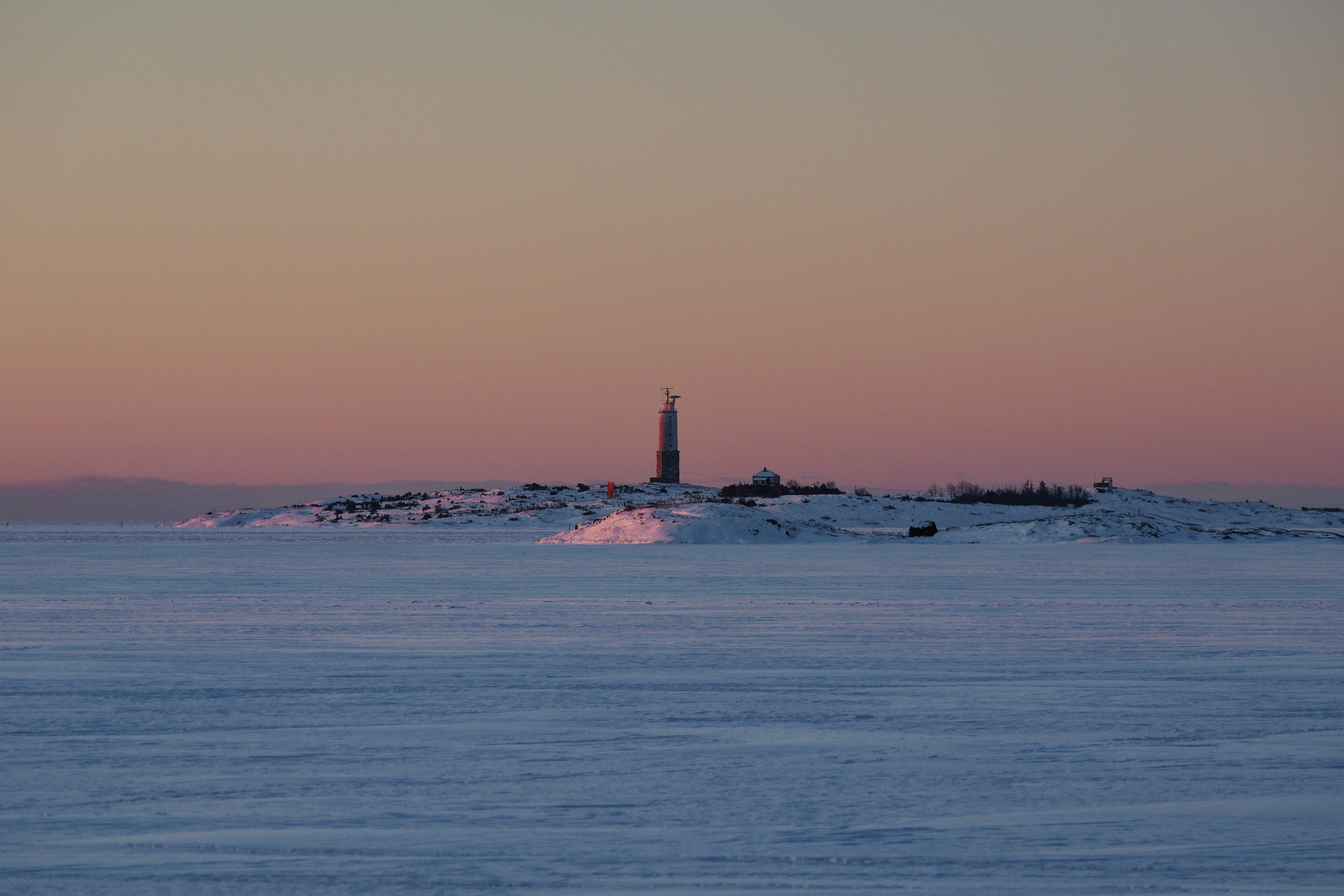 Lighthouse on a frozen island at sunset