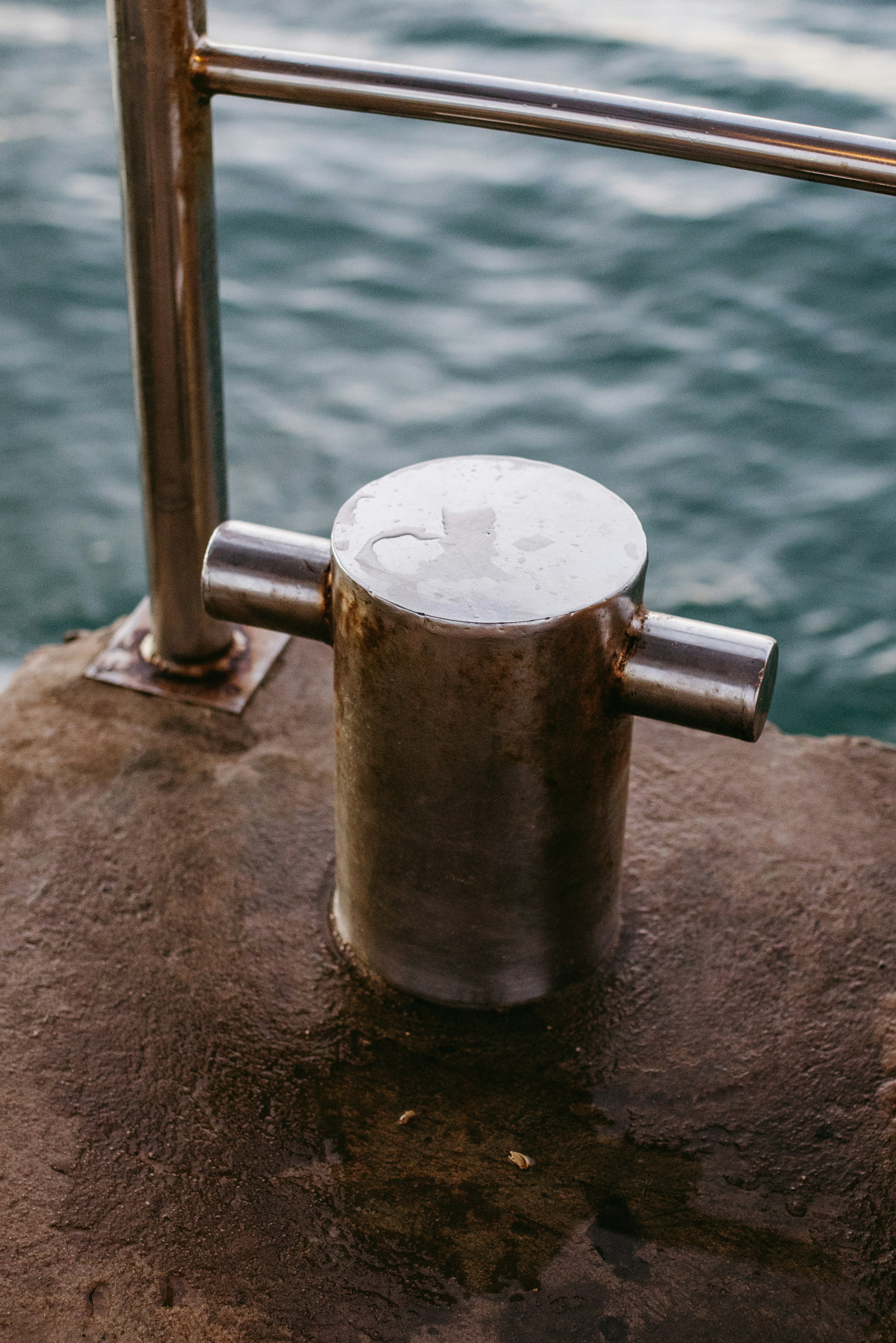 Metal bollard on a concrete dock by the water