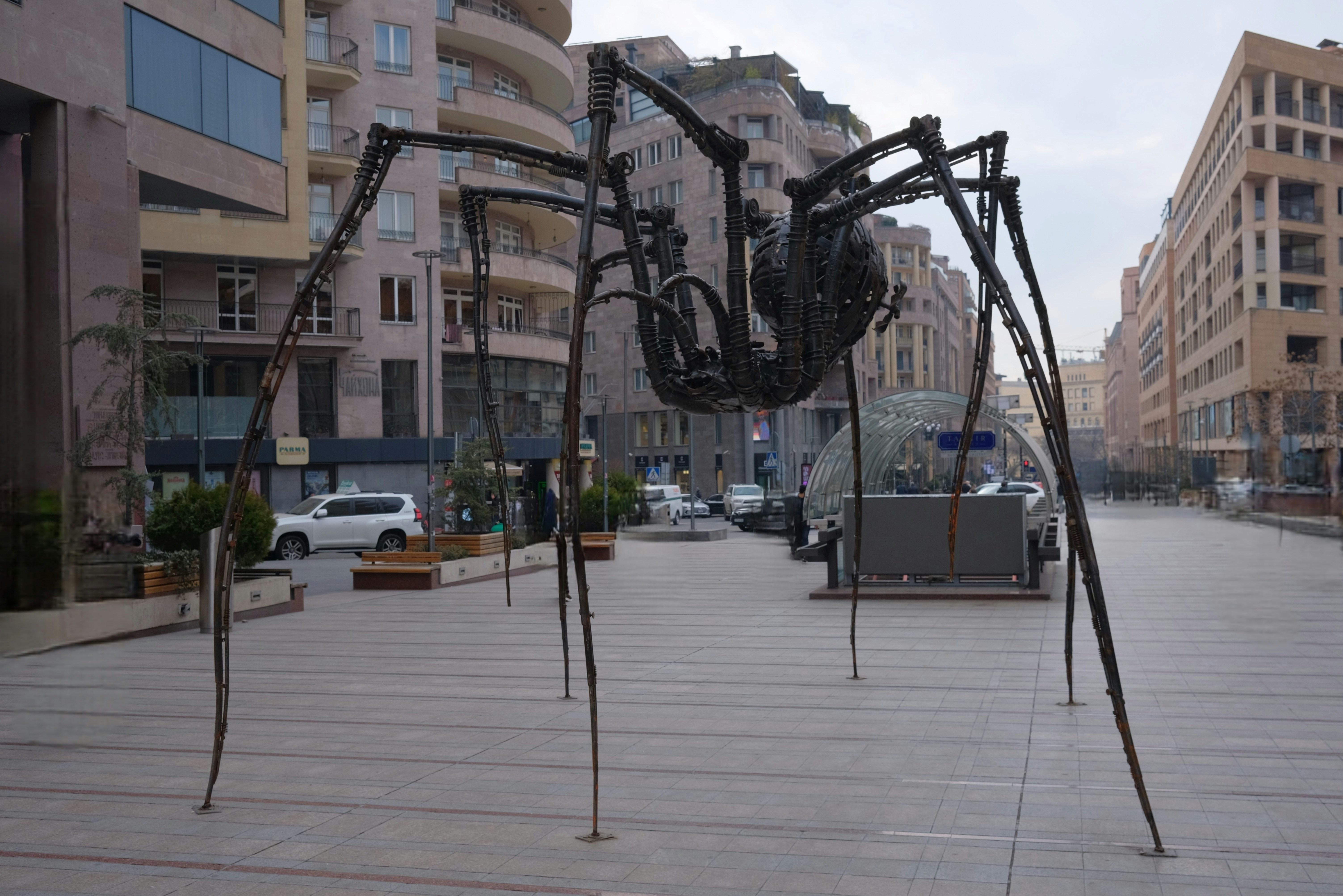 Large metal spider sculpture on city street
