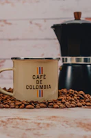 Mug of coffee with beans and moka pot.