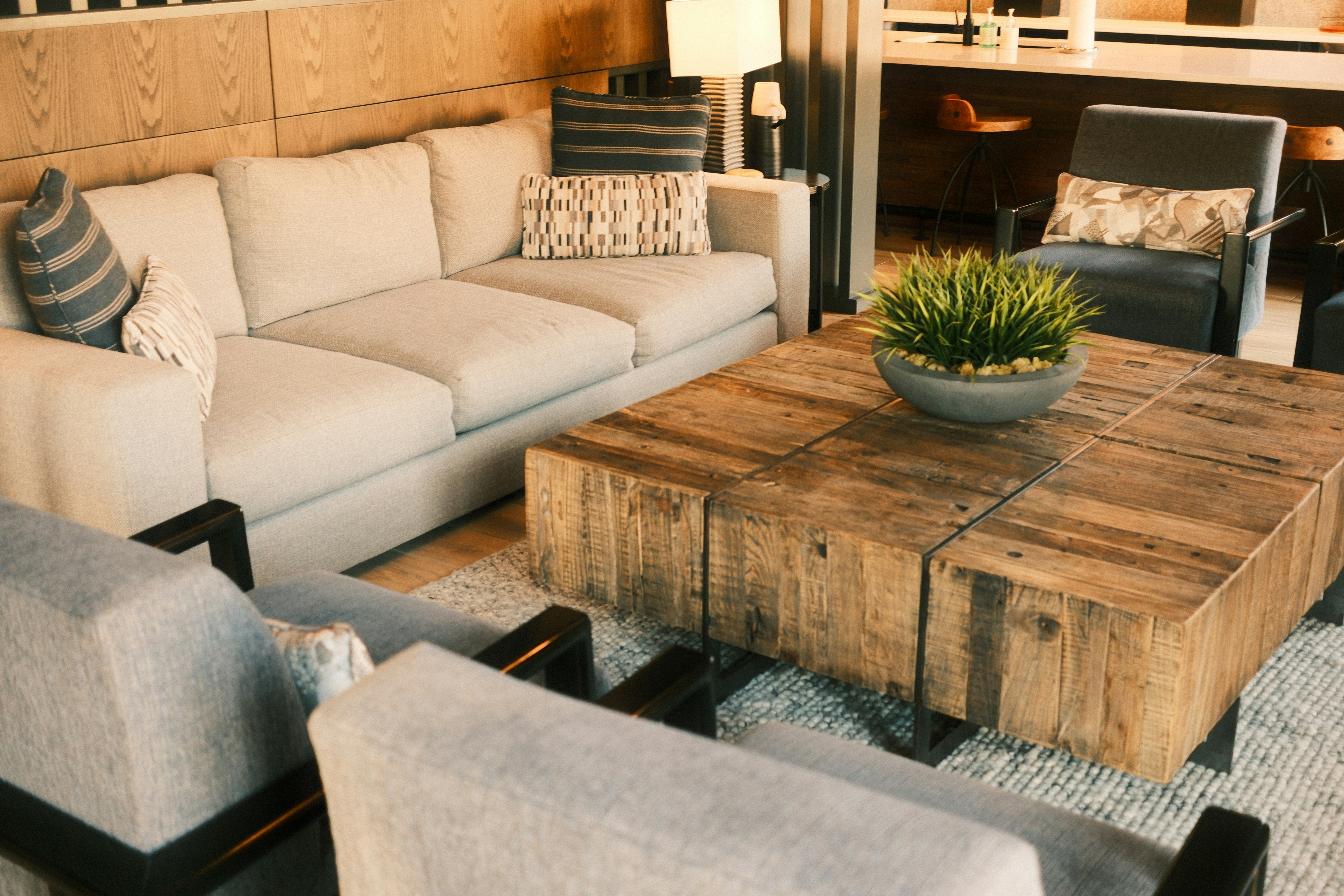 Modern living room with sectional sofa and rustic coffee table.