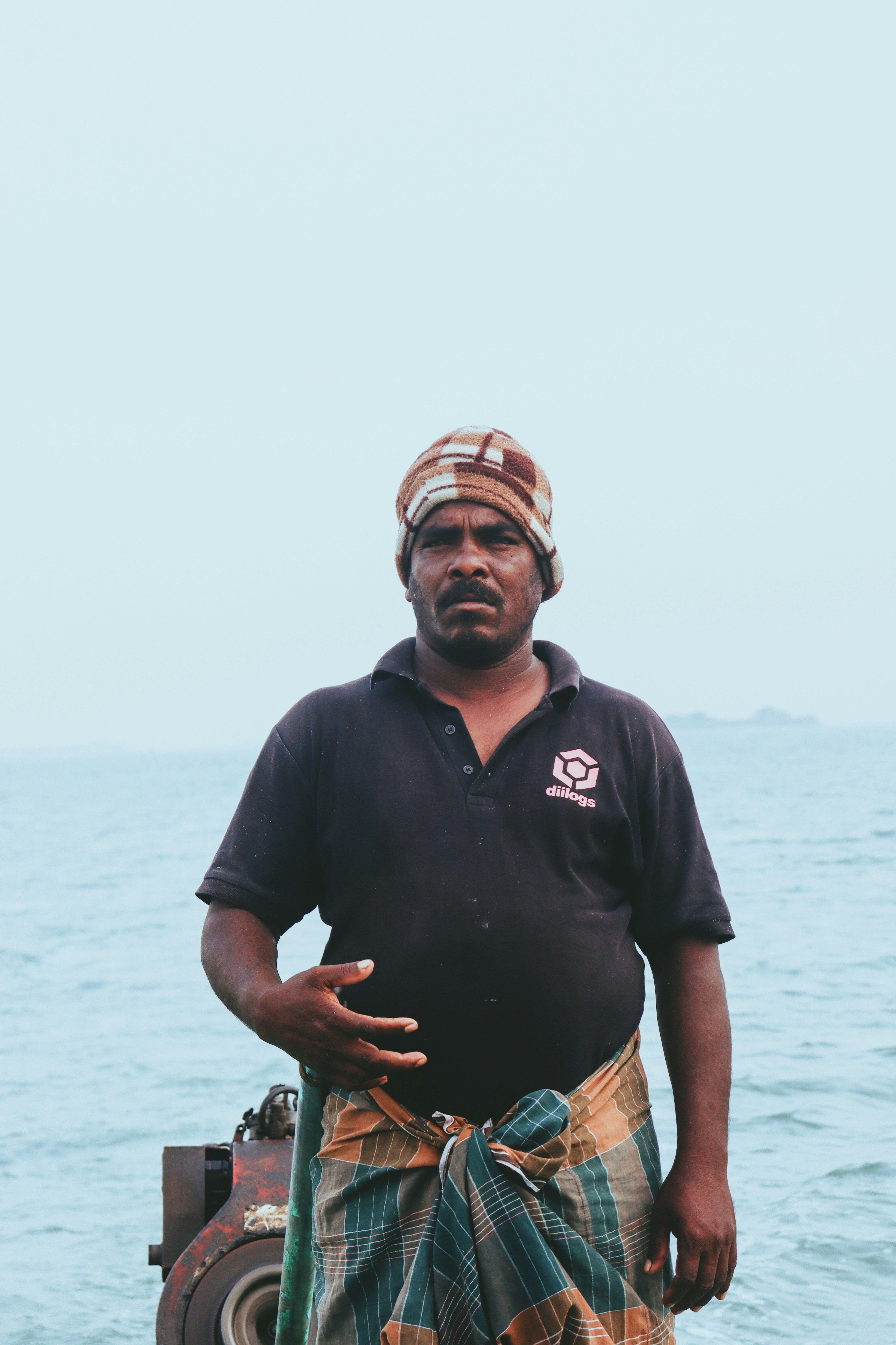 伝統的な服装を着た男が海辺に立っている。