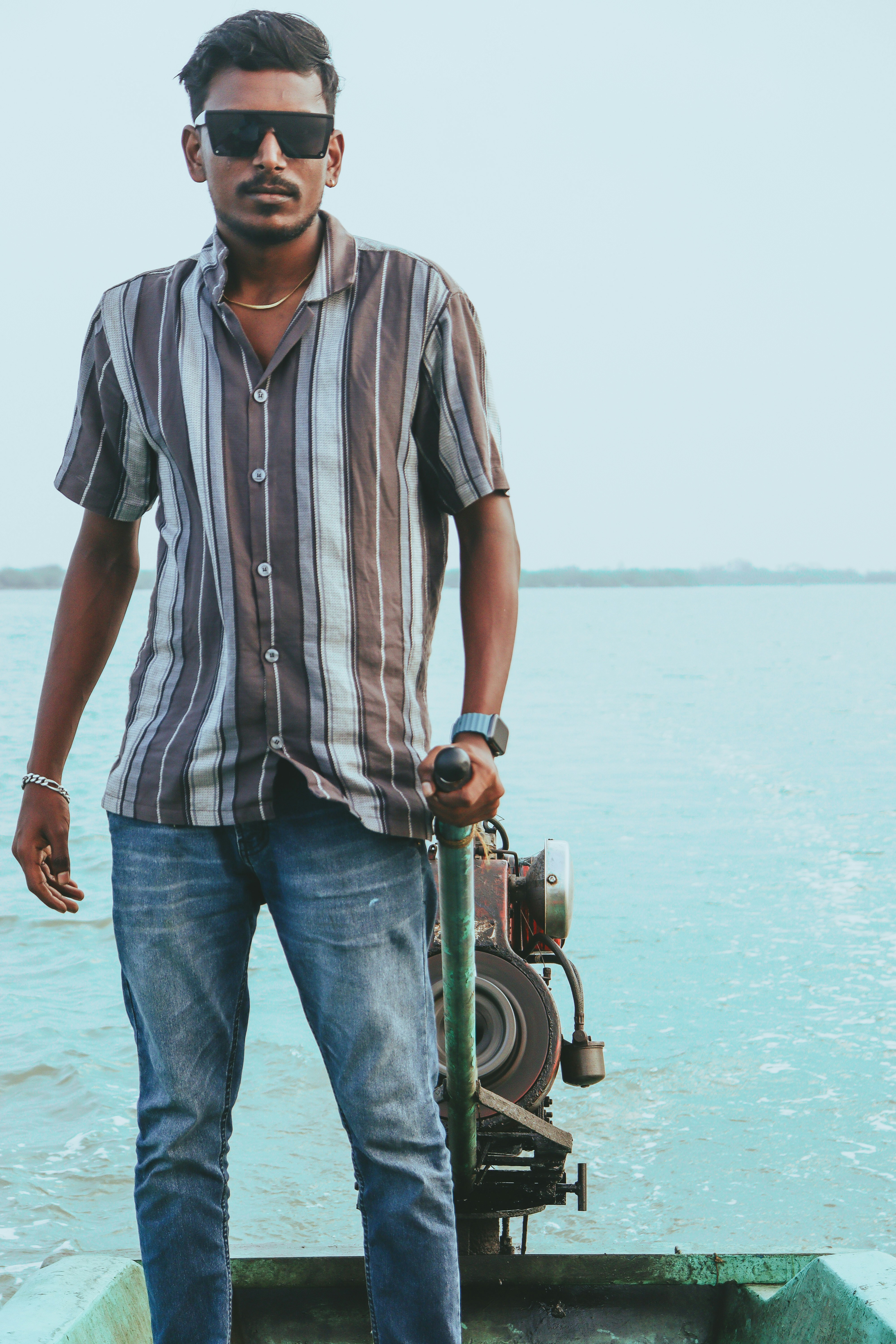 船の上に立ってハンドルを握る男。