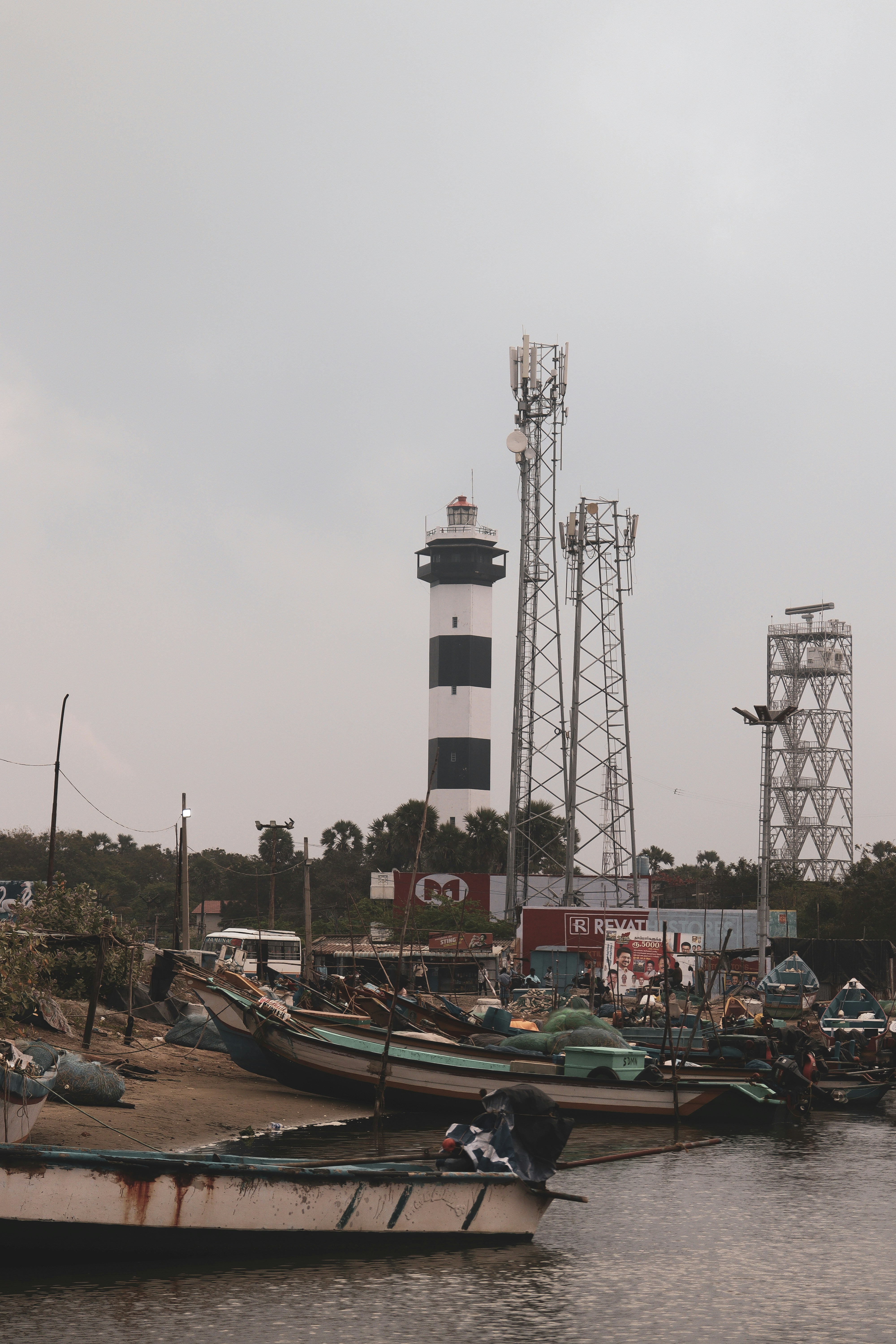 灯台や携帯電話の基地局が、係留中の漁船の上にそびえ立っています