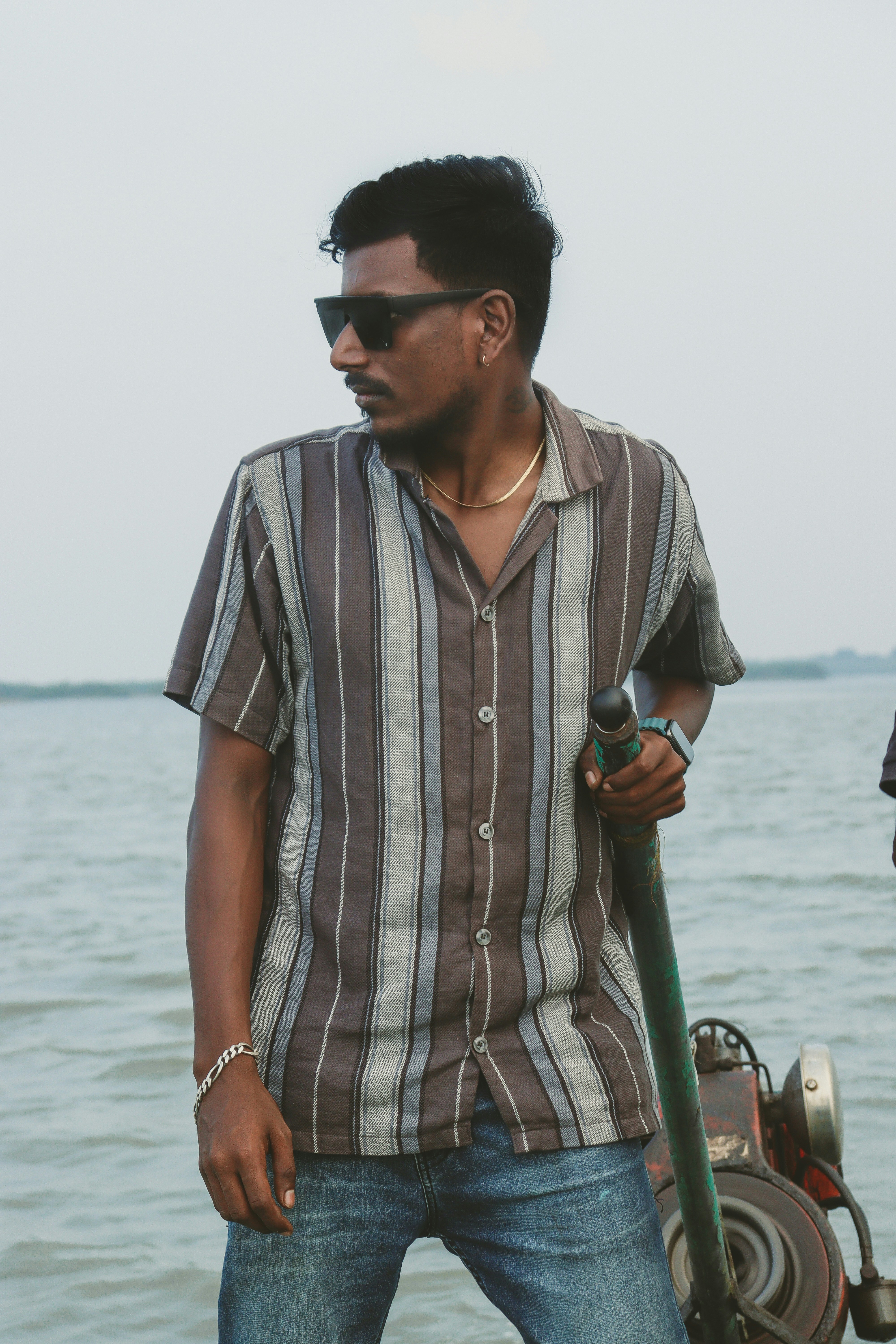 縞模様のシャツを着た男がボートの上に立っている