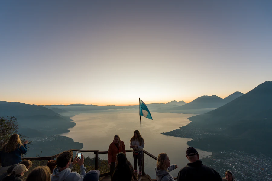 Personas mirando el amanecer sobre el lago con neblina desde La Nariz del Indio, Santa Clara La Laguna.