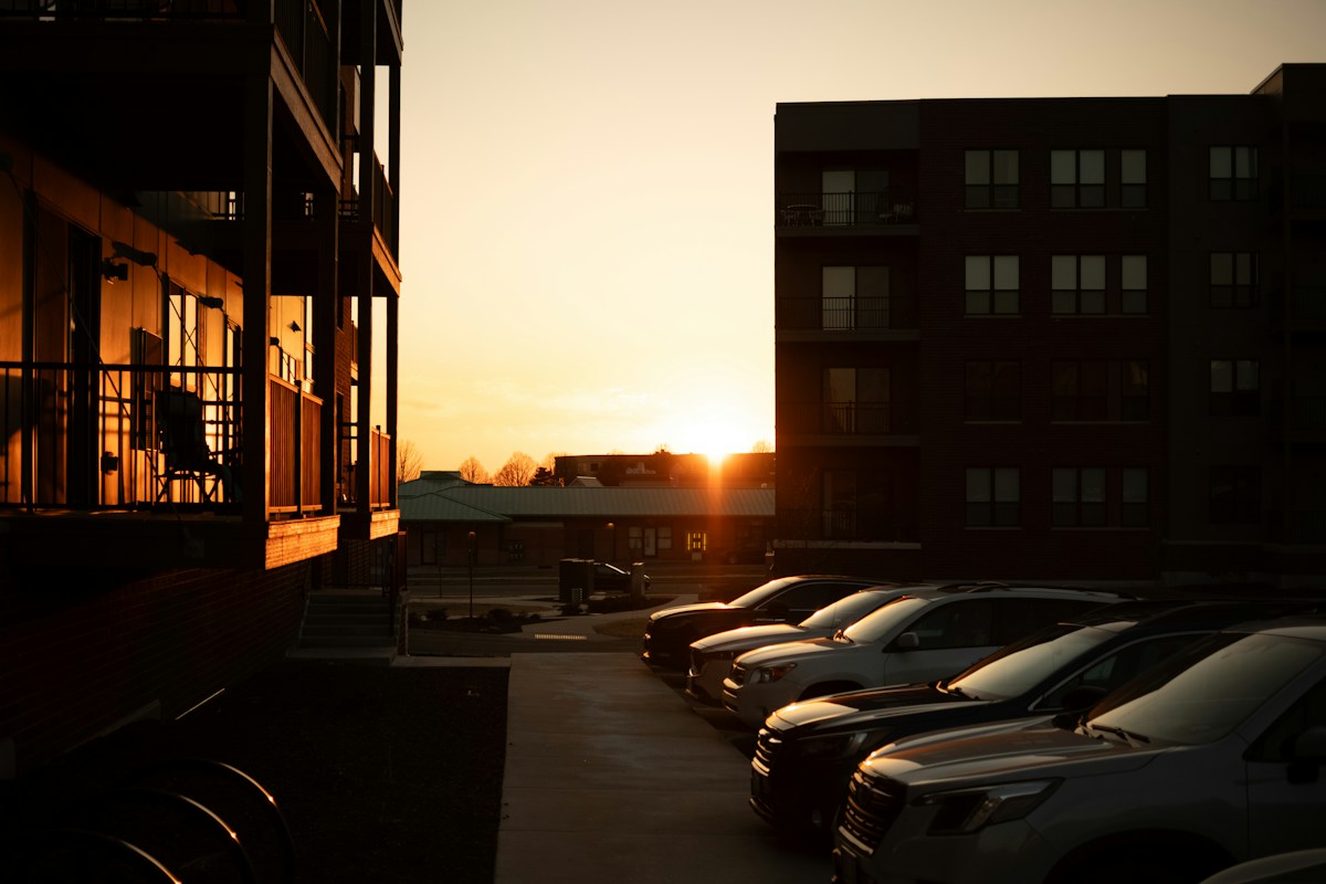 Sunset view of a parking lot with apartment buildings, illustrating a serene backdrop for community fall event ideas.