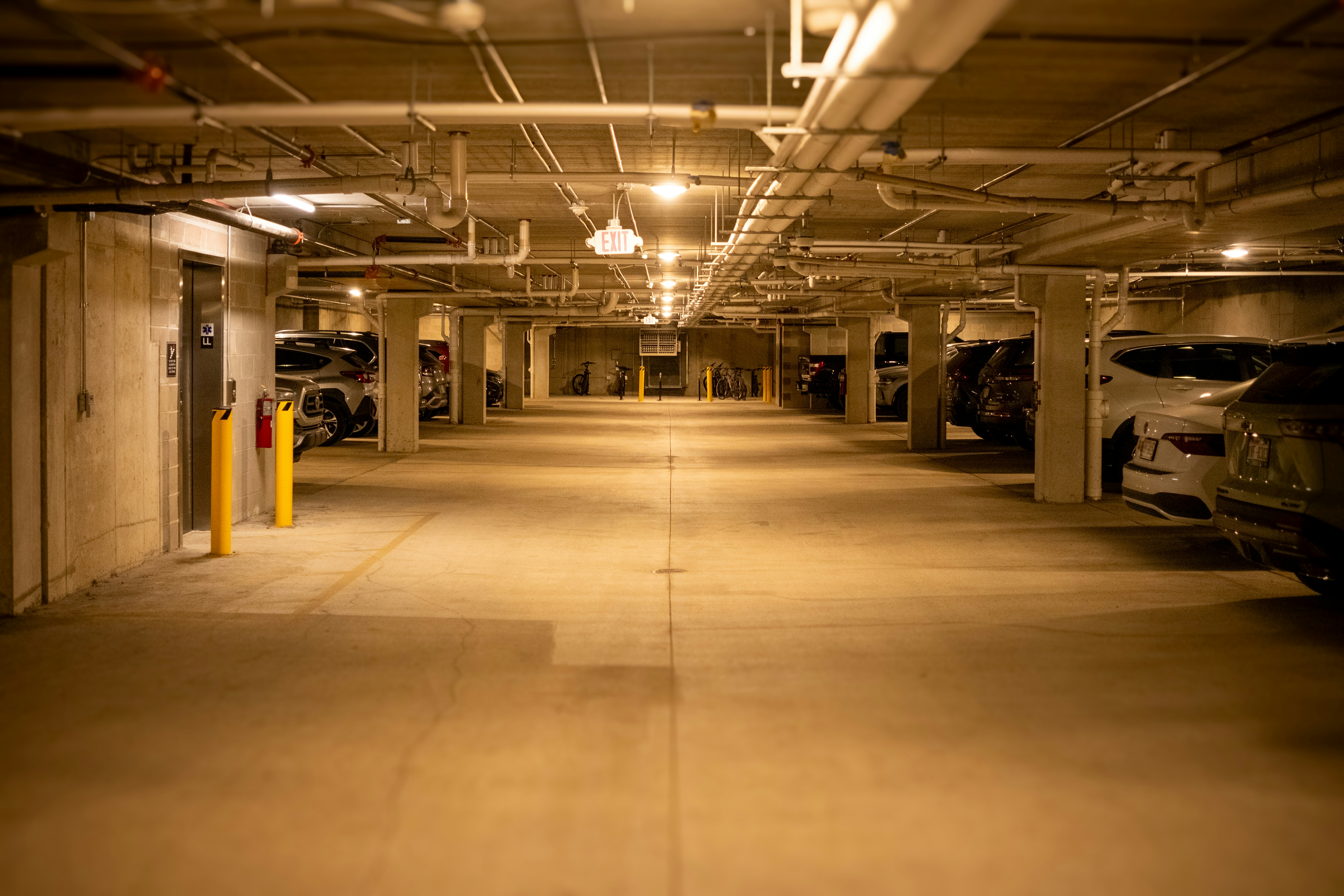Empty underground parking garage with cars visible